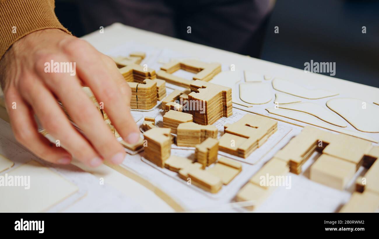 Nahaufnahme des Architekten Hand Checking Stadtmodell Konzept in seinem Heimatbüro. Stockfoto