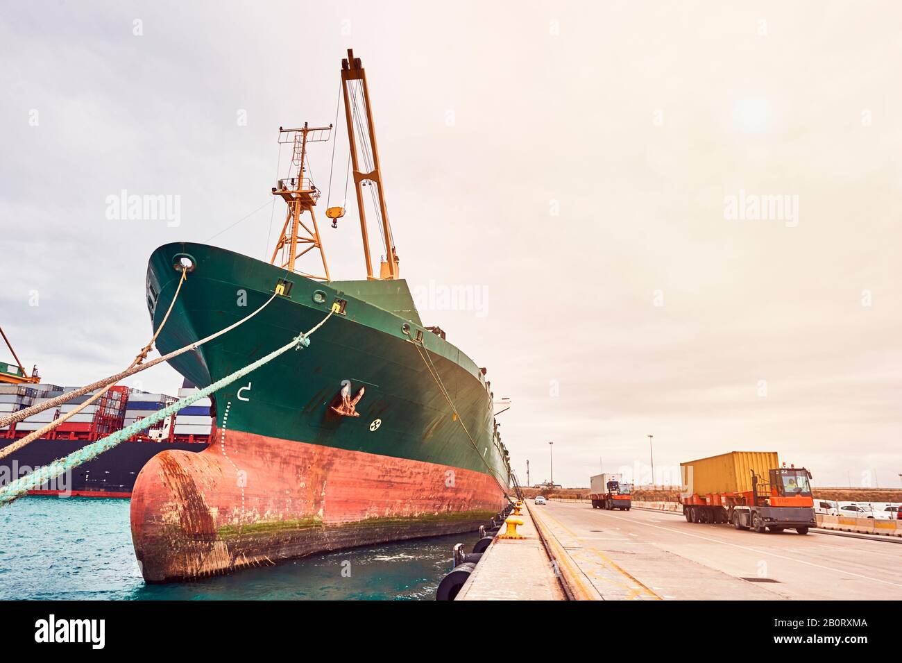 Container-Frachtschiff und Container-Lkw im Maritim-Hafen. Transportindustrie und Versandlogistik. Export und Import von Geschäften. Stockfoto