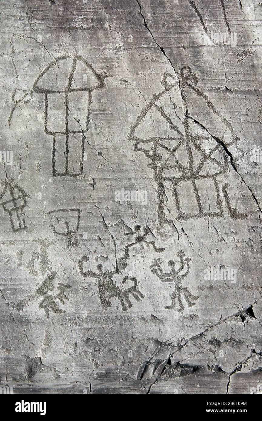 Petroglyph, Felsschnitzerei, eines Dorfes mit Häusern auf Stelzen und einer Zeremonie. In der Eisenzeit zwischen 1000 und 1200 v. Chr. von den alten Camunni eingemeißelt Stockfoto