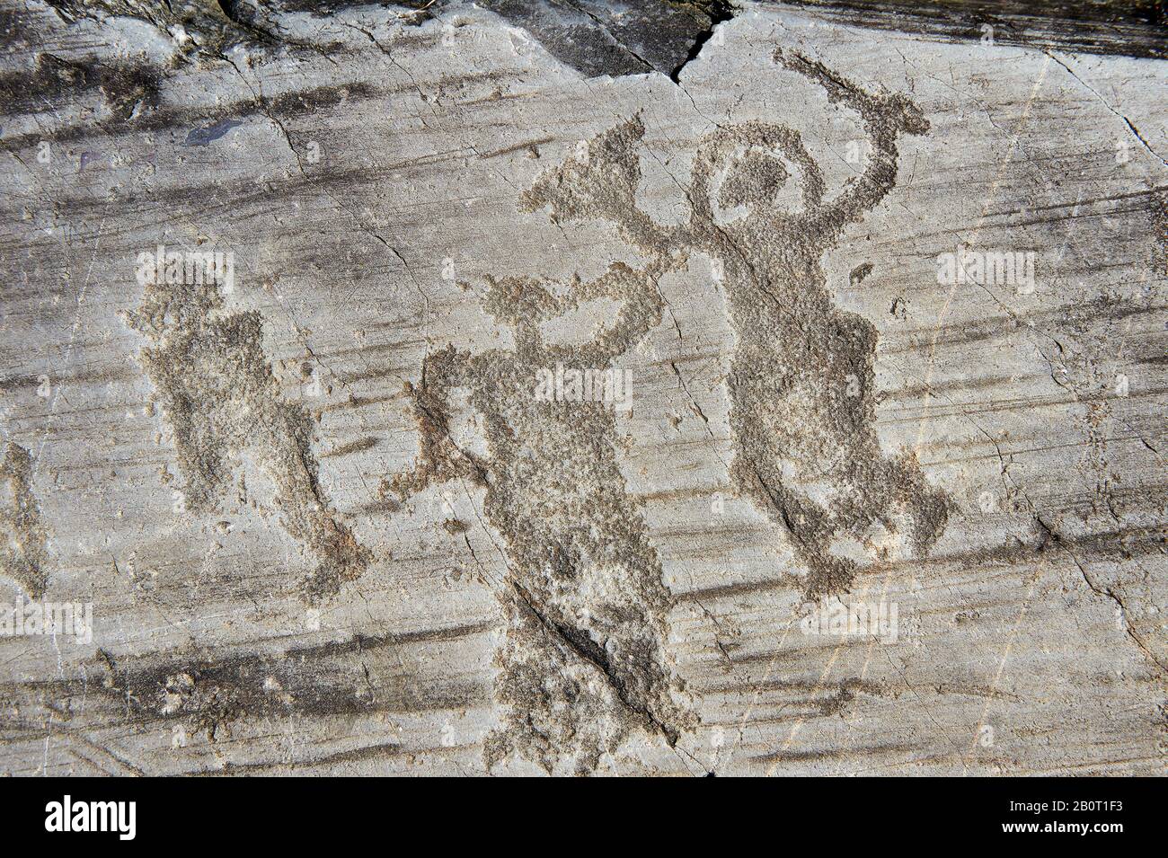 Petroglyph, Felsschnitzerei, von zwei Kriegern, die einen Helm tragen und ein Schwert und einen Schild tragen. Von den alten Camuni-Leuten in der Eisenzeit gehauen Stockfoto