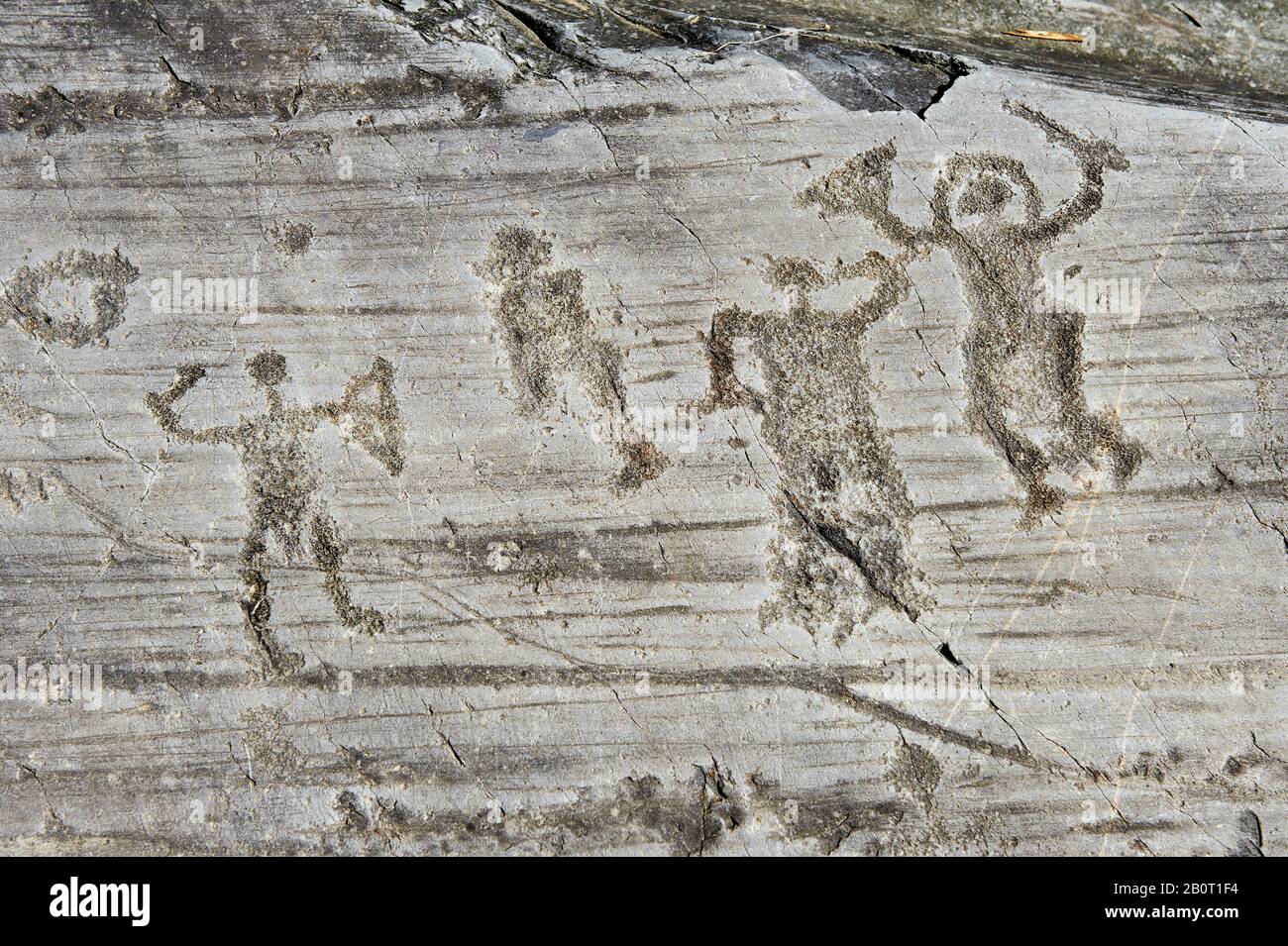 Petroglyph, Felsschnitzerei einer Gruppe von Kriegern, die einen Helm tragen und Schwert und Schild tragen. Von den alten Camuni-Leuten im IRO geschnitzt Stockfoto
