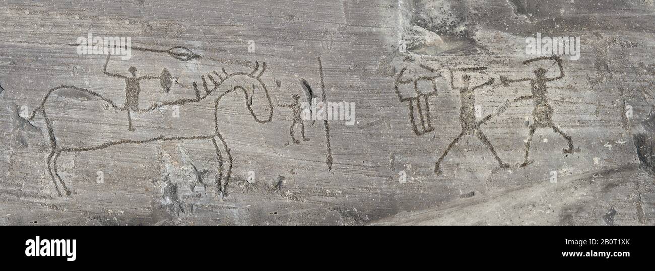 Petroglyph, Felsschnitzerei, eines Mannes auf dem Rücken mit einem Speer und zwei Krieger, die mit Schwertern kämpfen, die von den alten Camuni-Leuten im Eisen A eingeritzt wurden Stockfoto