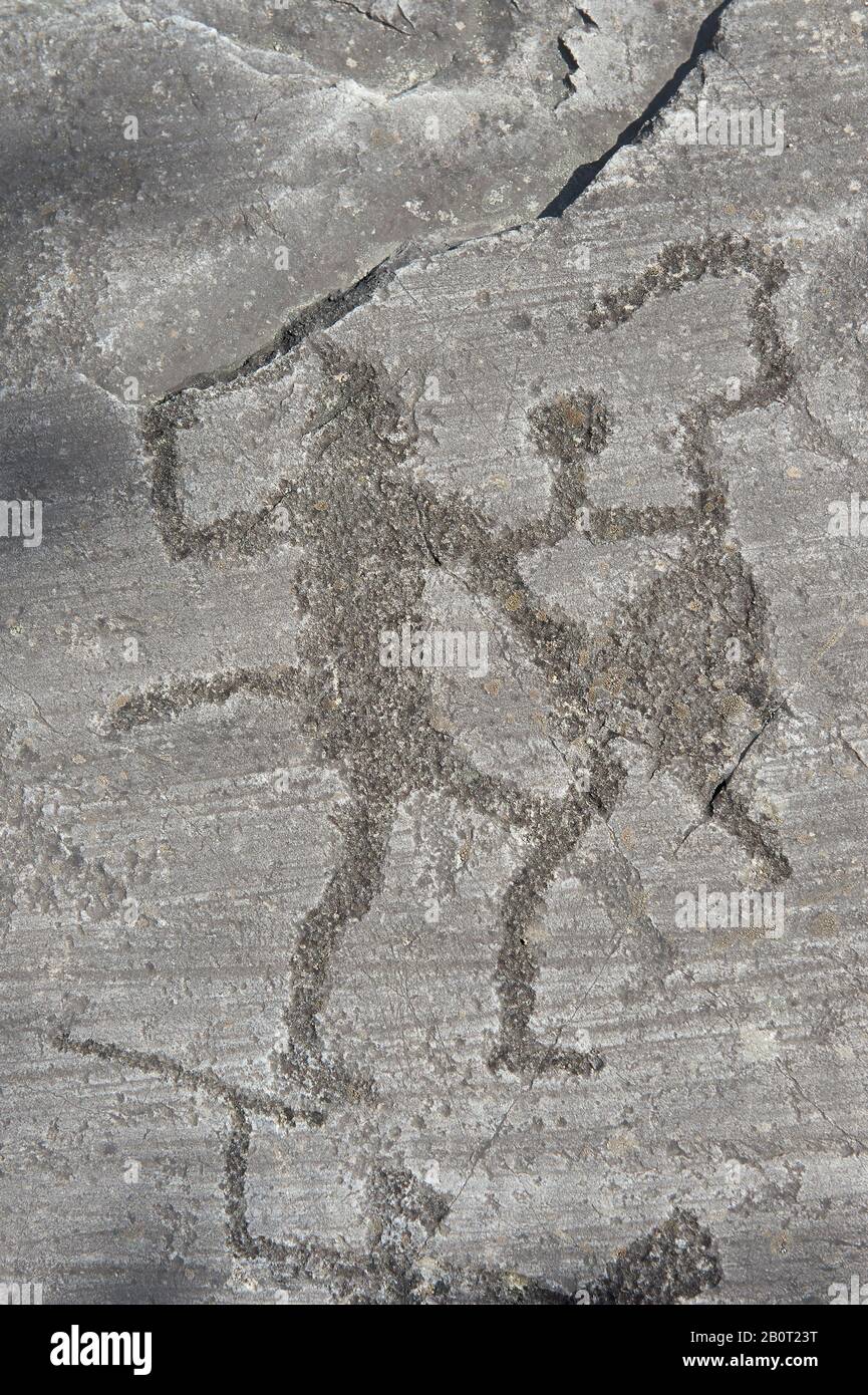 Petroglyph, Felsschnitzerei, von zwei Kriegern, die mit Schwertern und Schilden kämpfen, die von den alten Camuni-Leuten in der Eisenzeit zwischen 900 und 1200 v. Chr. geschnitzt wurden. Stockfoto