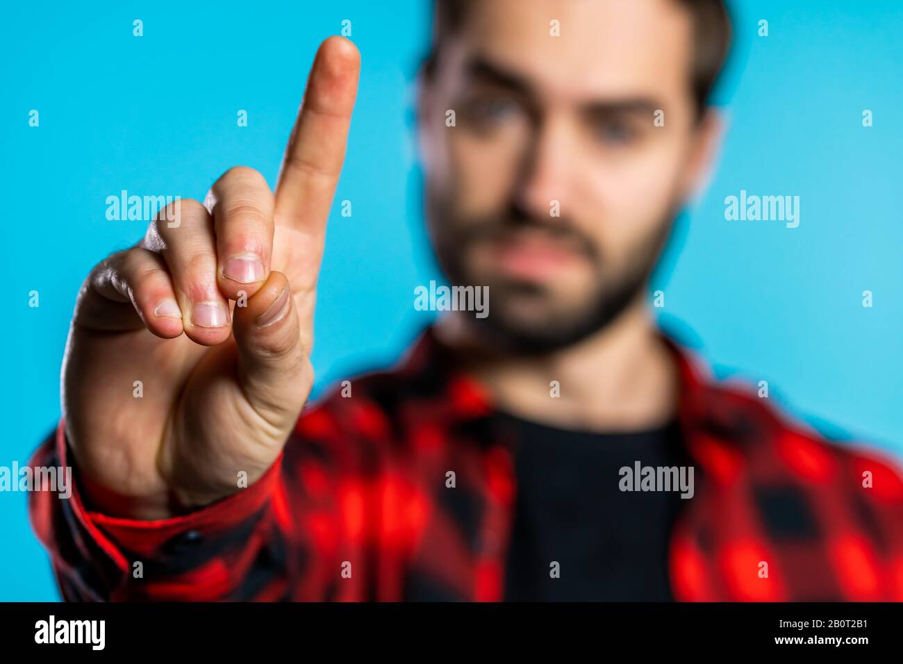Der Mann, der ohne Handfingerzeichen missbilligt, macht eine negative Fingergeste. Ablehnend, Ablehnend, Nicht Einverstanden, Porträt des gutaussehenden Kerls. Stockfoto