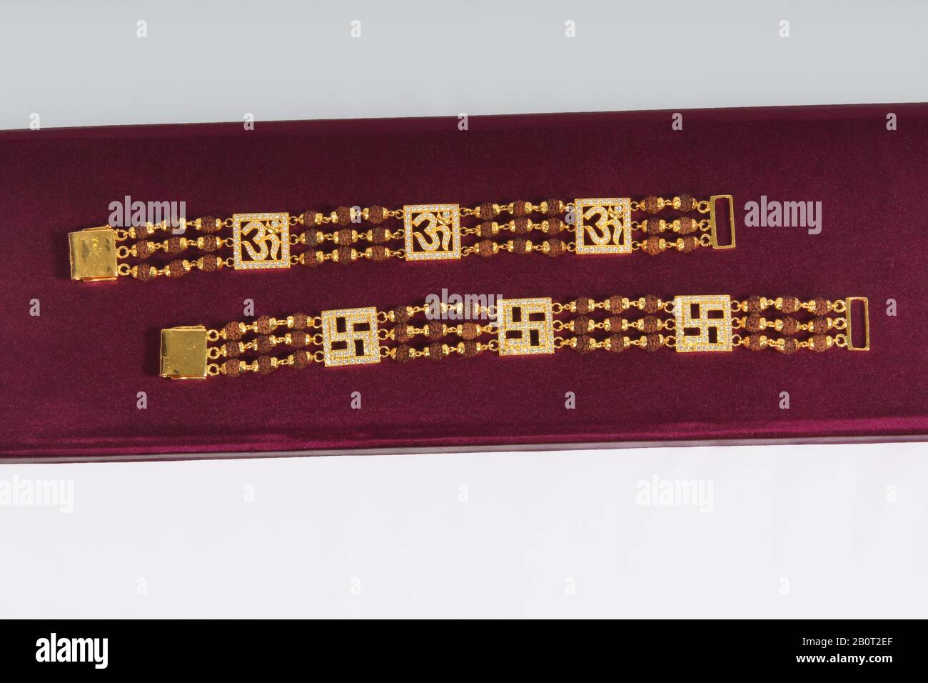 Goldrudraksha-Samen, der als Prachtwulst im Hinduismus-Armband mit OM-Zeichen verwendet wird Stockfoto