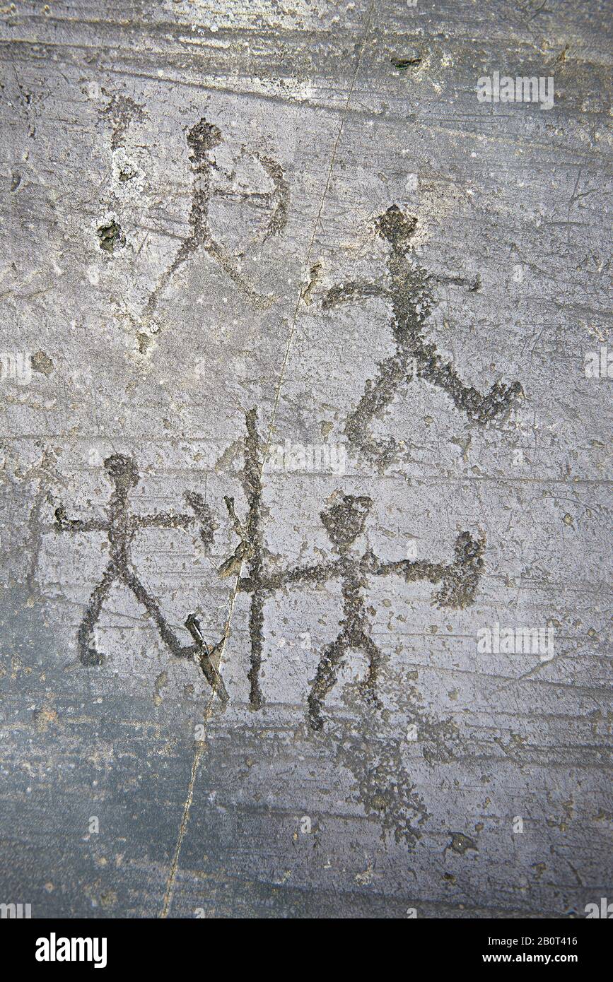 Prähistorische Petroglyphe, Felsschnitzerei, von Kriegern mit Speerschilden und einem Bogen, der von den Camunni im Eisenzeit zwischen 1000-1600 v. Chr., Se geschnitzt wurde Stockfoto