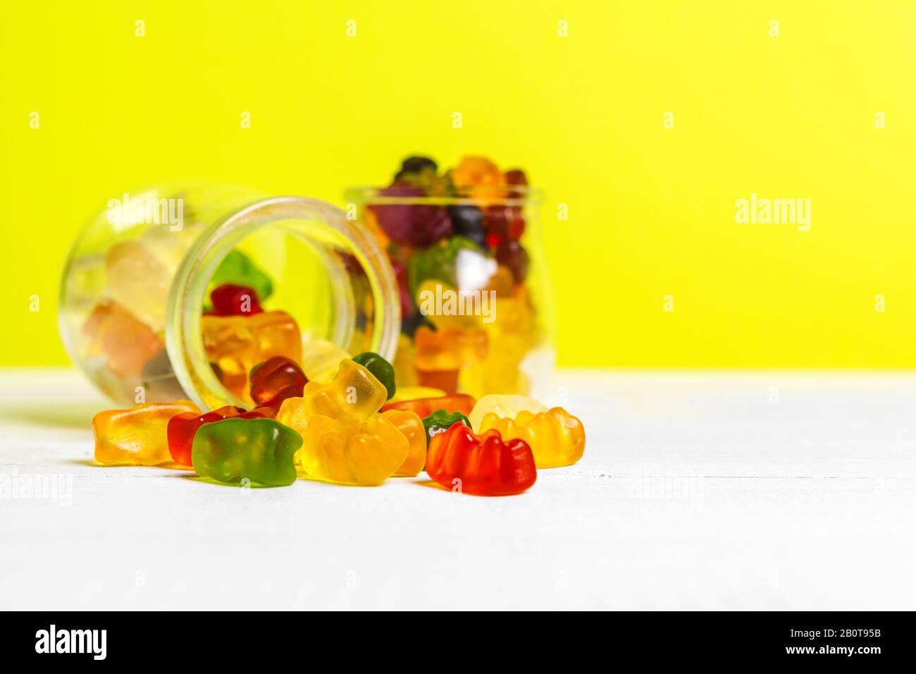 Flaschen mit Süßigkeiten auf dem Tisch. Kreatives Foto. Stockfoto