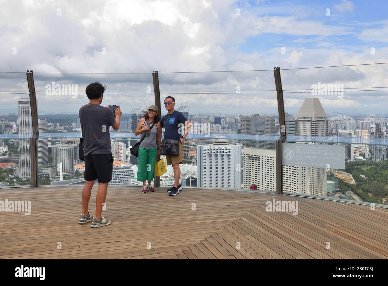 Touristen, die von der Aussichtsplattform Sands SkyPark aus Fotos von der Stadt Singapur machen Stockfoto