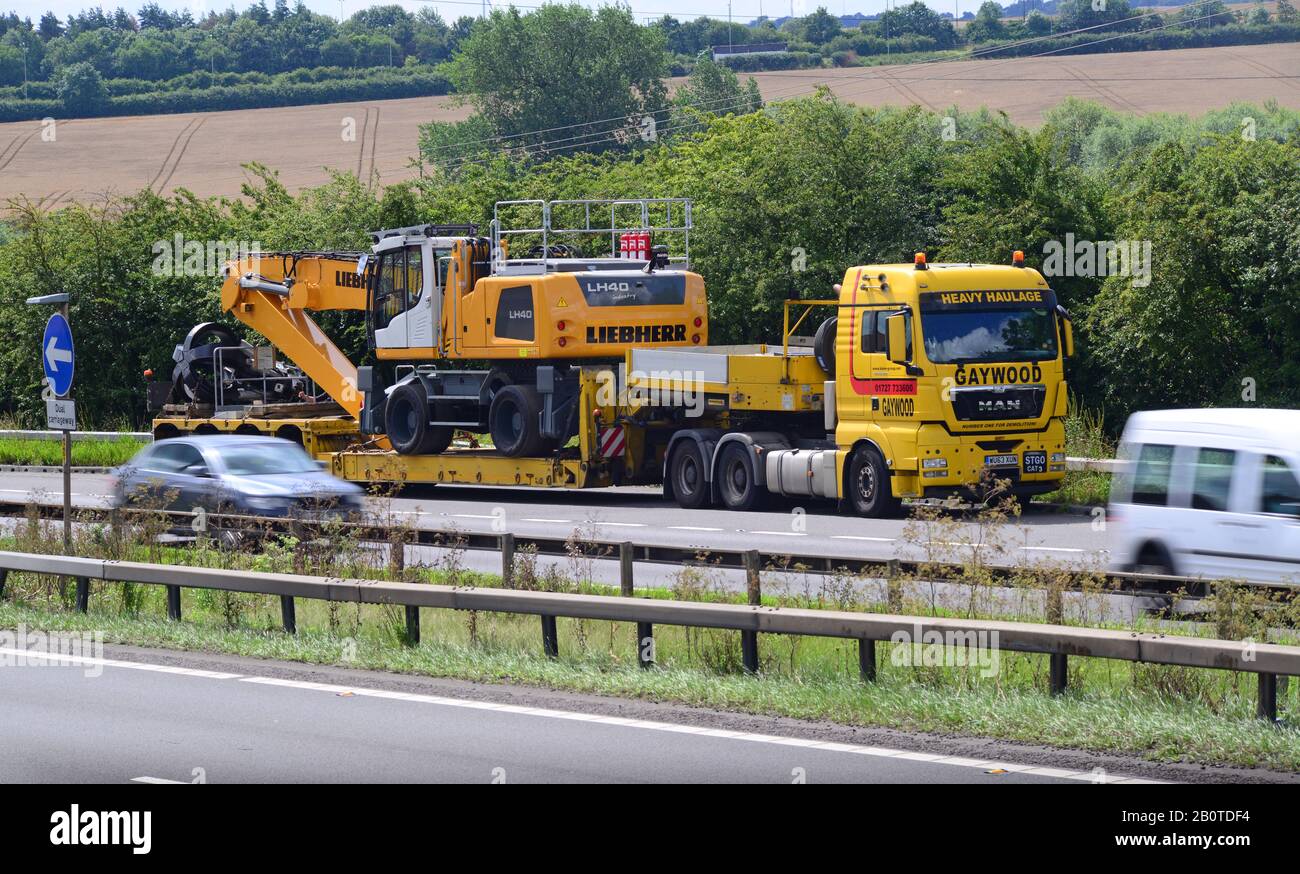 Tieflader, der Raupengräber mit sich führt, der auf der AUTOBAHN A1/M leeds united Kingdom eine Pause im Lay-by einlegen kann Stockfoto