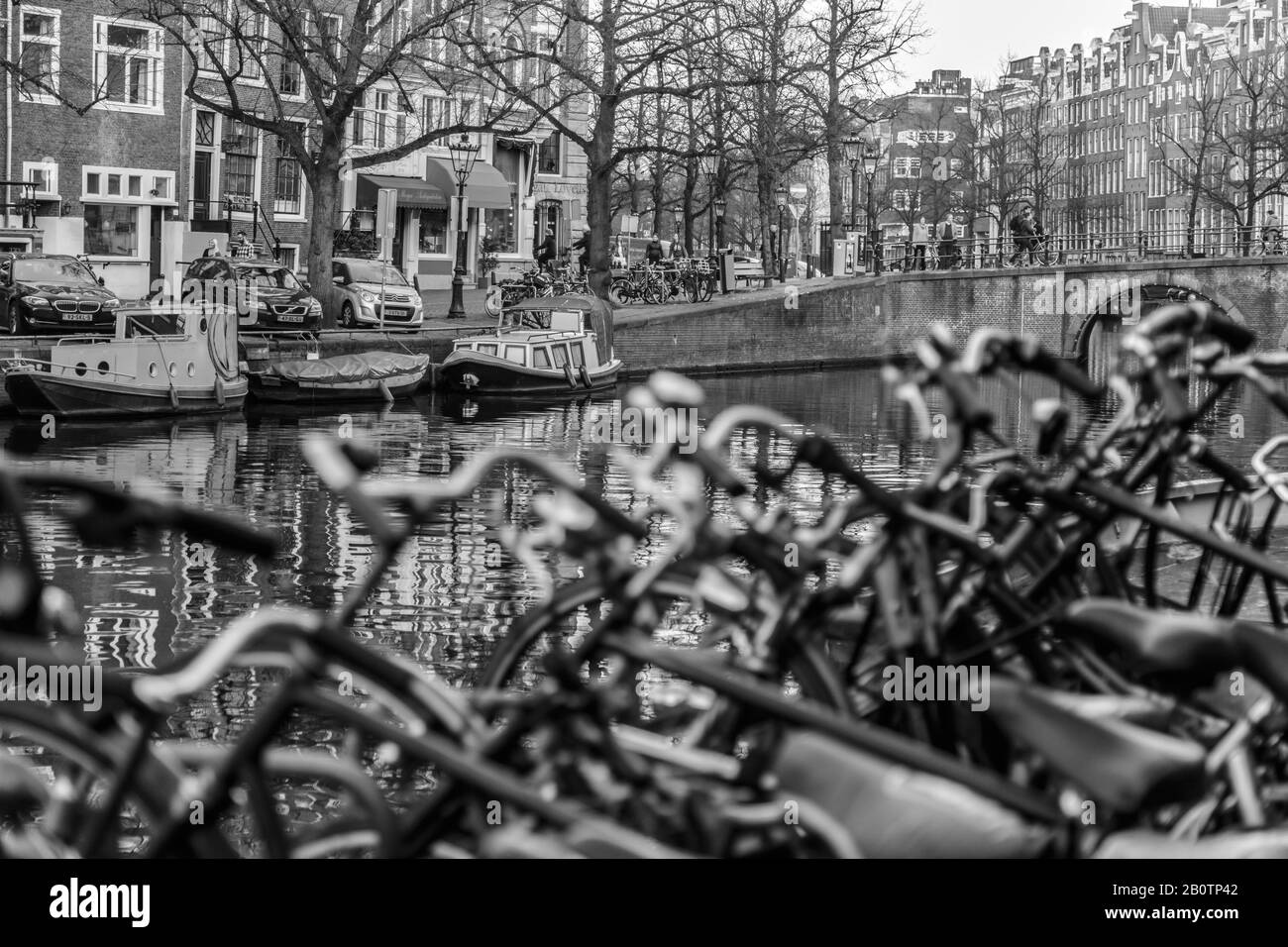 Fahrräder und Kanäle sind ein typischer Anblick von Amsterdam. Hausboote und Architektur aus dem 18. Jahrhundert säumen die Straßen von Wohngebieten. Stockfoto