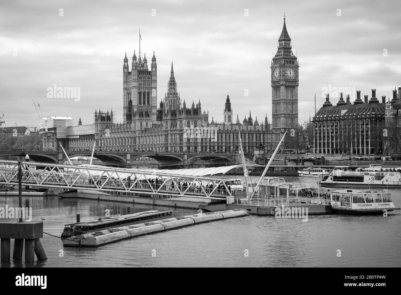 Touristen steigen an Bord des Flussschiffs, um die Sehenswürdigkeiten zu besichtigen. Im Hintergrund sitzen Houses of Parliament, Westminster Bridge und Big Ben. Stockfoto