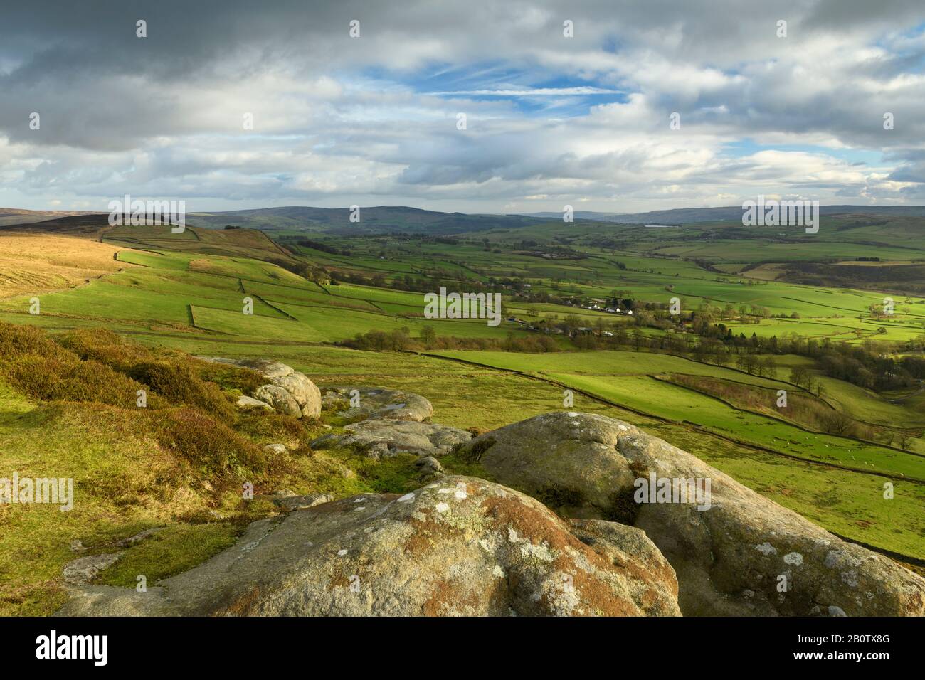 Landschaftlich schöner Blick von Embsay Crag (sonnenbeleuchtete Fells oder Moore, Bauernfelder im Tal, hohe Hügel, dramatischer Himmel) - North Yorkshire, England, Großbritannien. Stockfoto