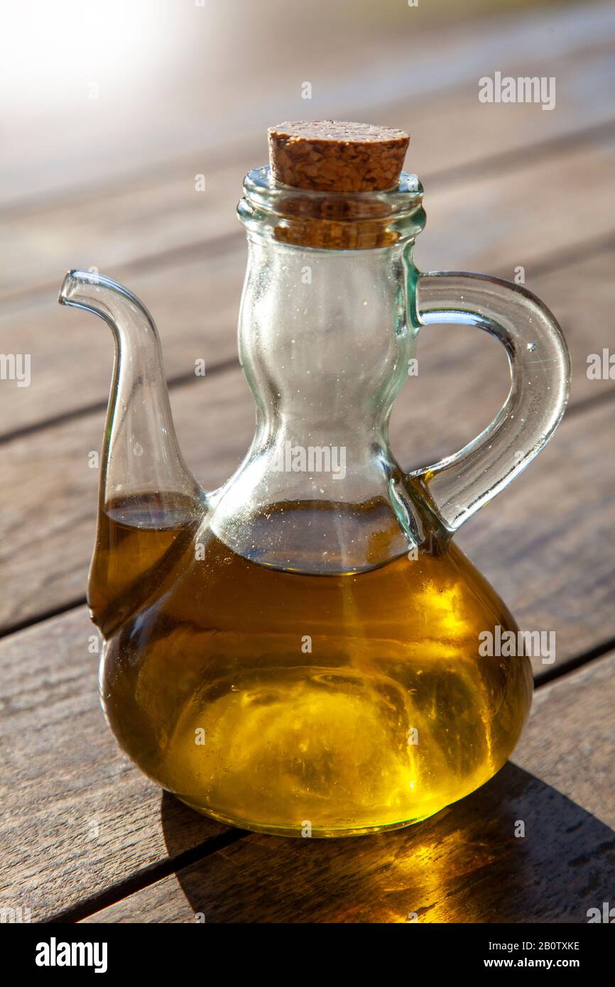 Kleine Glasflasche mit Ölablass für Olivenöl, das in der Sonne auf dem Restauranttisch in Goriska Brda, Slowenien, fotografiert wird Stockfoto