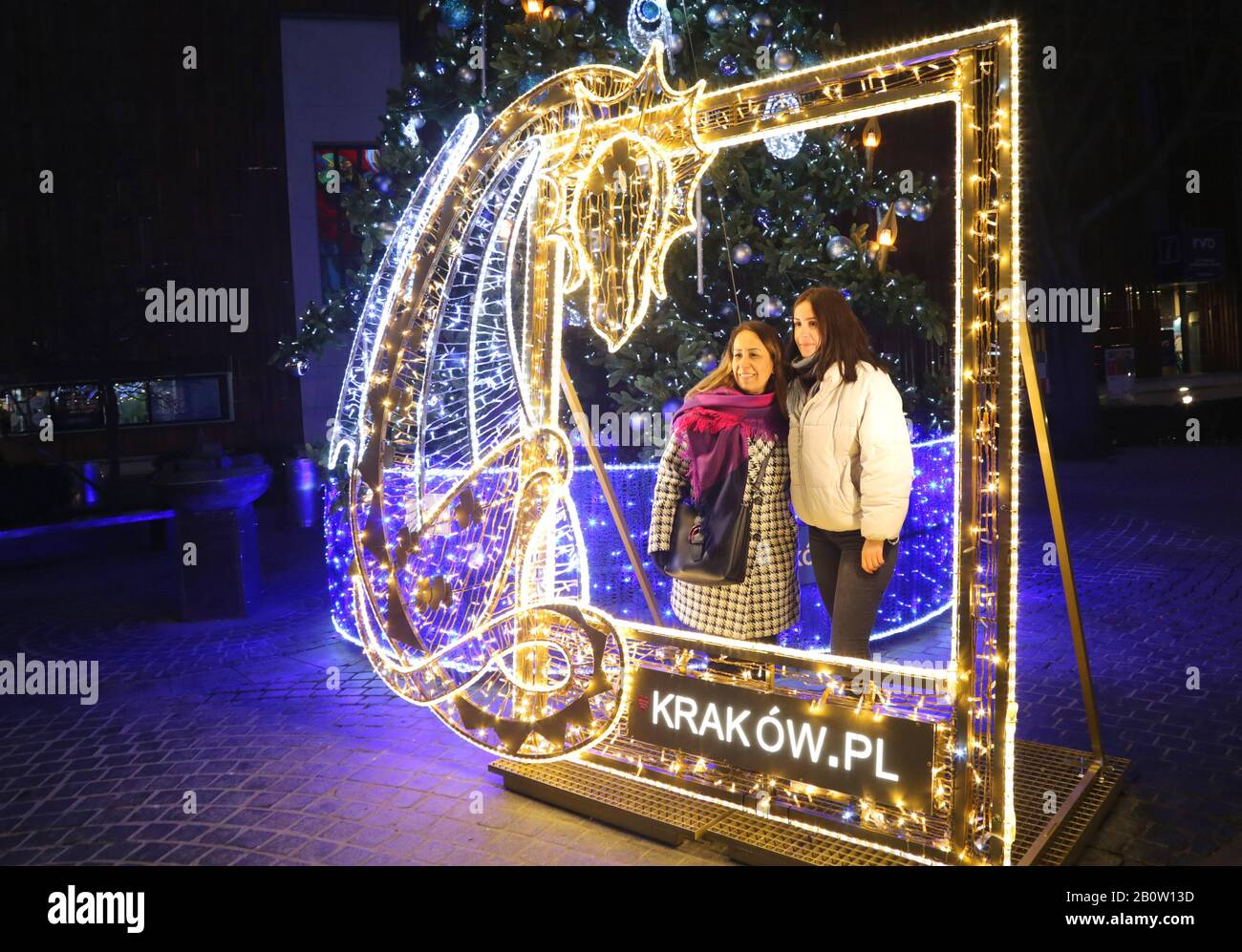 Krakauer. Krakow. Polen. Zwei Touristen posieren für den Schnappschuss im LED-Rahmen und sagen "krakow.pl". Stockfoto