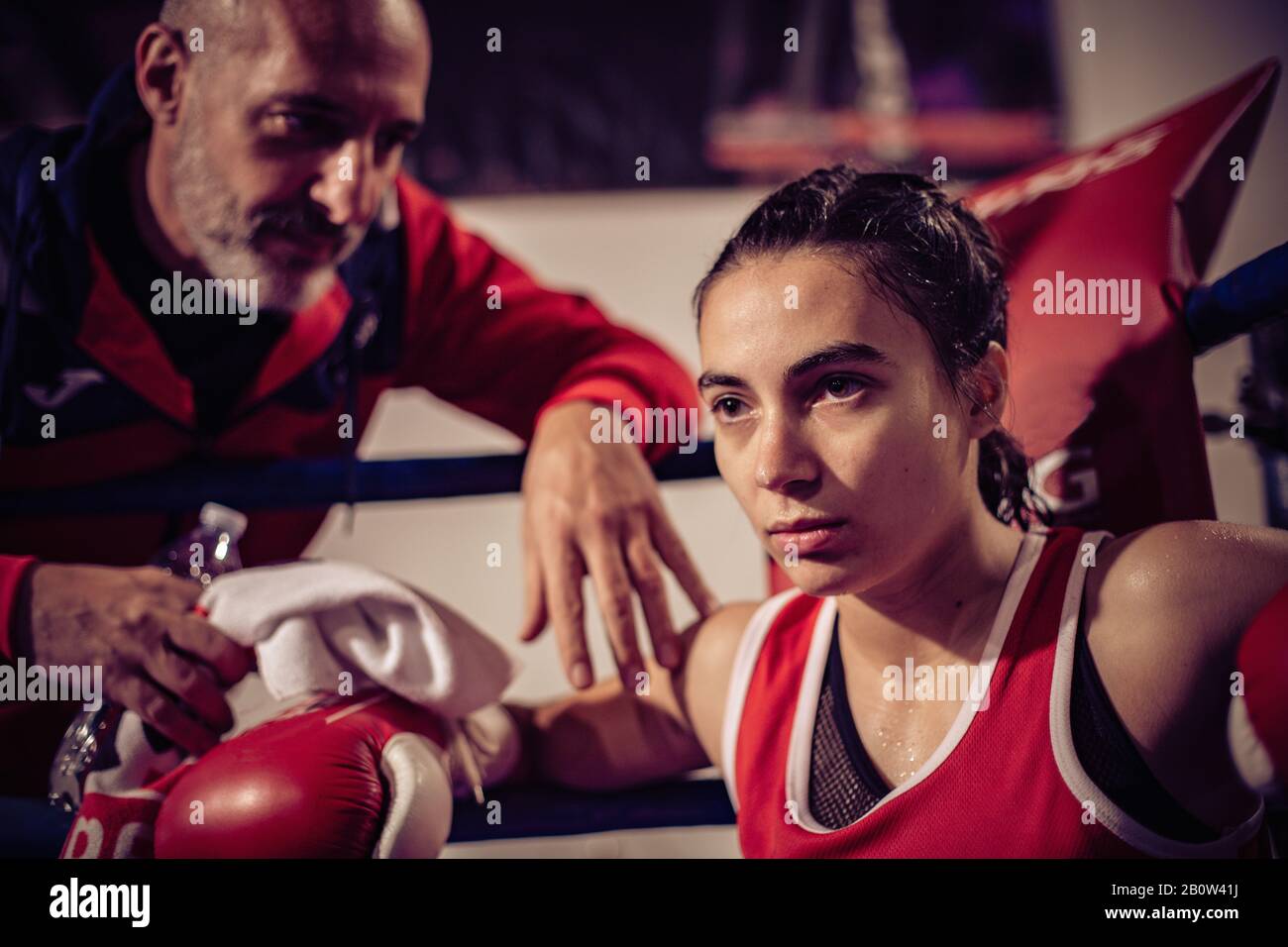 Porträt des Boxtrainers und des Boxboxers, der im Boxring sitzt. Stockfoto