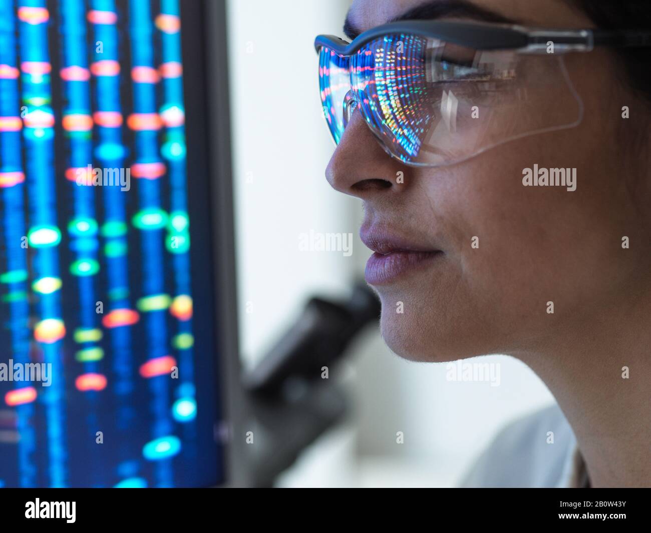 Genforschung, Wissenschaftlerin, die ein DNA-Profil einer menschlichen Probe auf einem Bildschirm im Labor betrachtet. Stockfoto