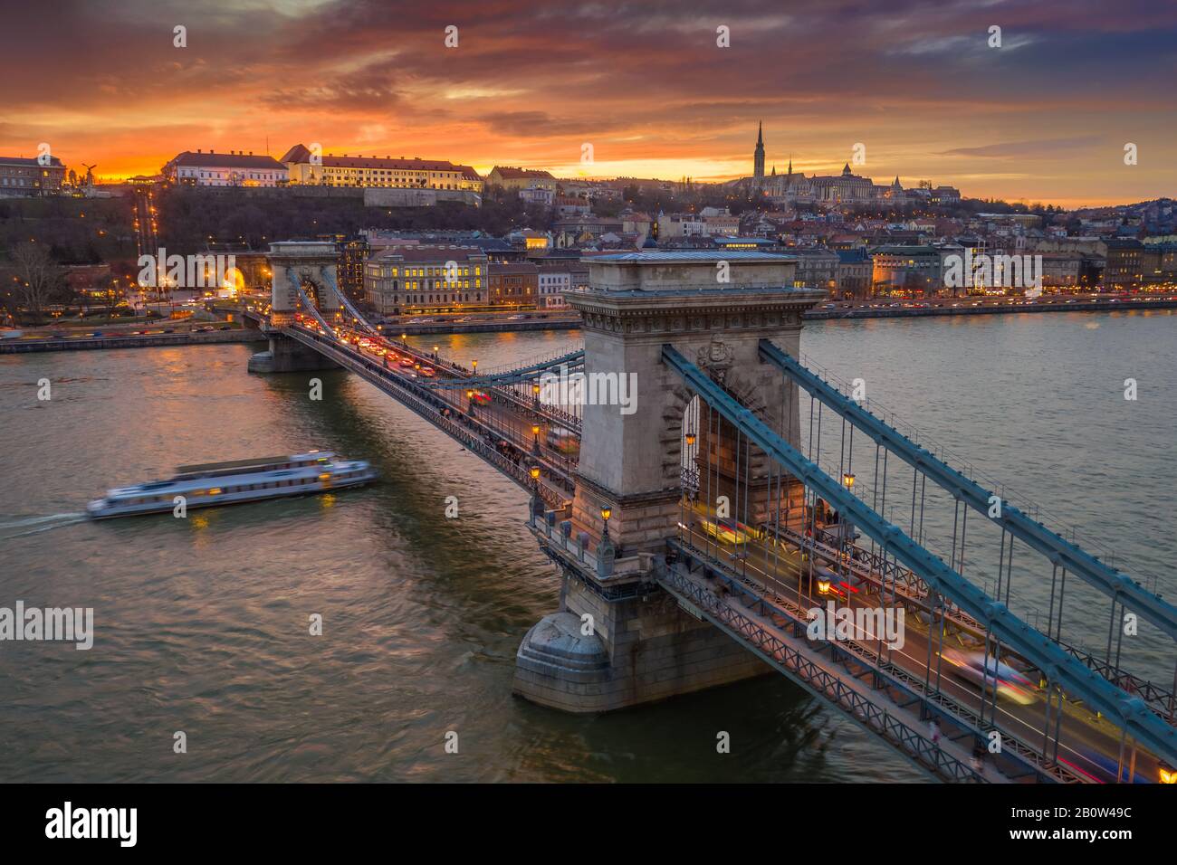 Budapest, Ungarn - Blick Auf die berühmte Szechenyi-Kettenbrücke mit einem schönen goldenen Sonnenuntergang im Winter. Matthias Kirche und Fisherman's Ba Stockfoto