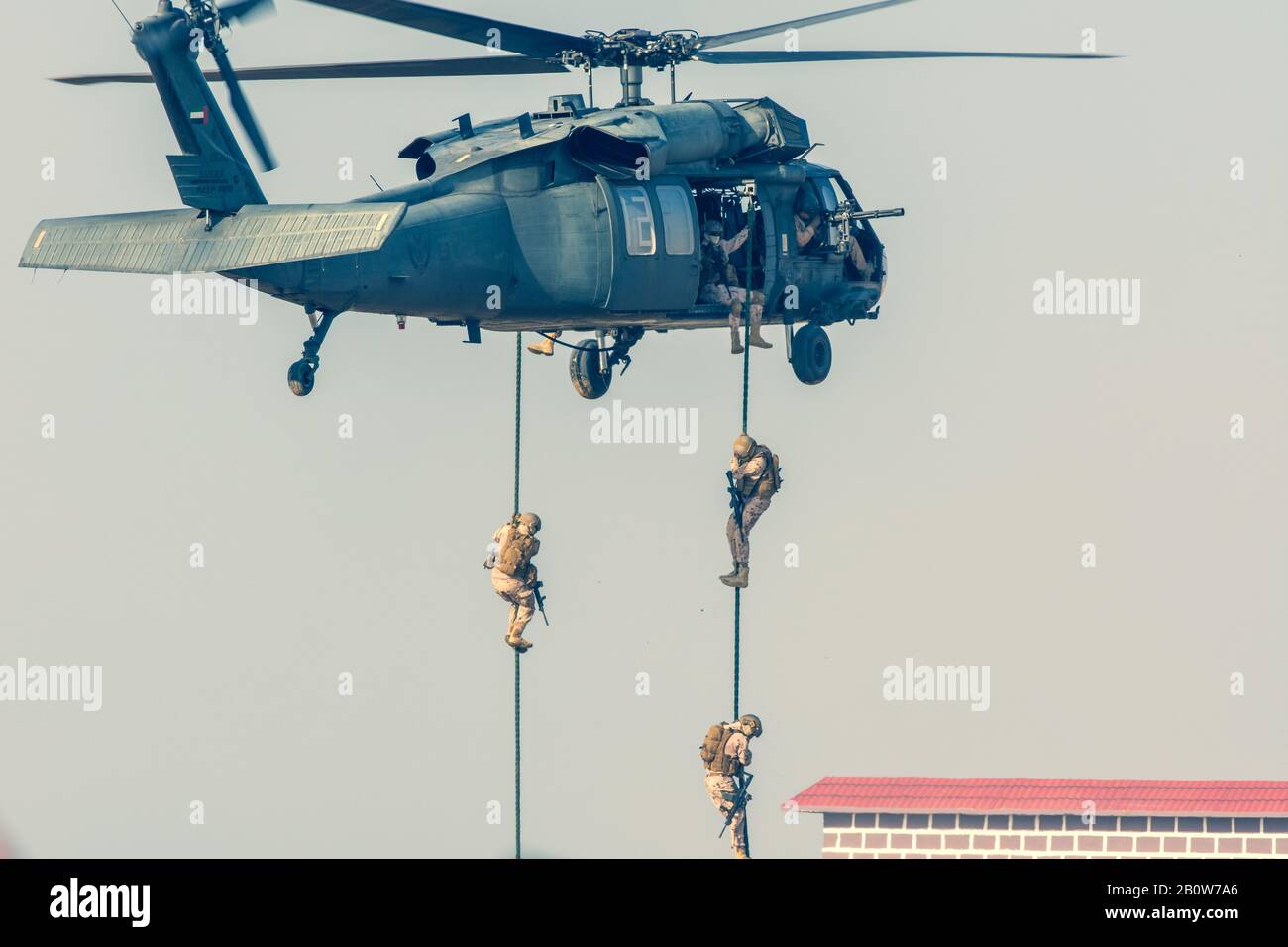Militärischen Kampf und Krieg mit dem Hubschrauber in das Chaos und Zerstörung zu fliegen. Soldaten aus Seil auf den Boden von Chopper aussetzen. Militärisches Konzept Stockfoto