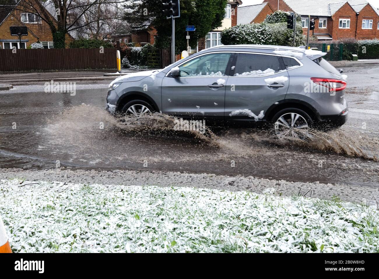 Fahrzeug durch eine große Pfütze Stockfoto