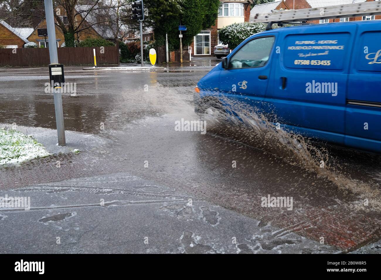 Fahrzeug durch eine große Pfütze Stockfoto