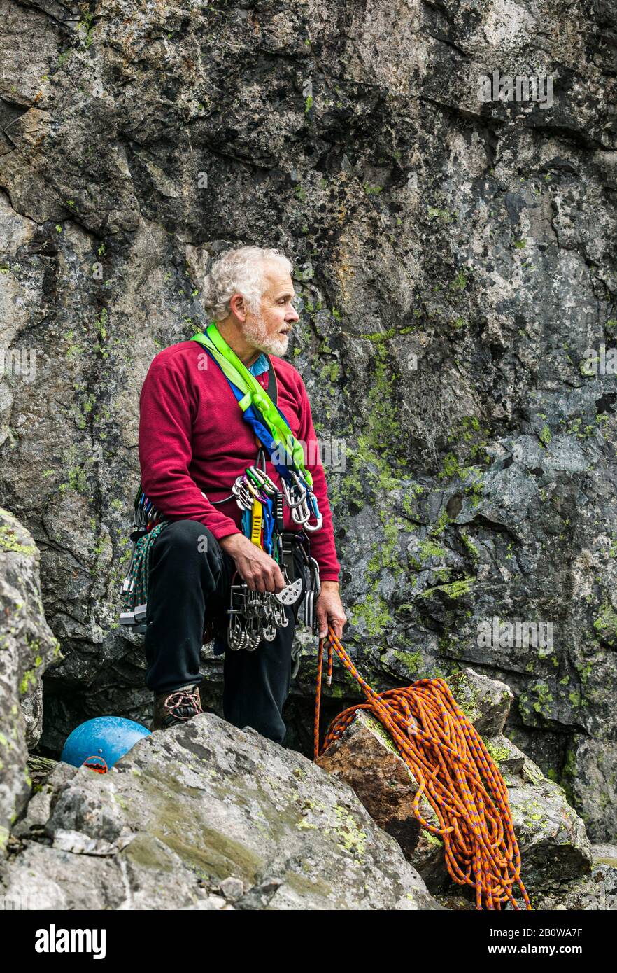 Ein Porträt eines reifen männlichen Felskletterers, während er sich auf einen Felsklettern vorbereitet. Stockfoto