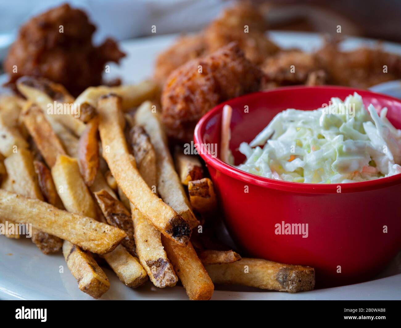 Nahaufnahme von Pommes frites, cole Slaw und Kokosnussgarnelen Stockfoto