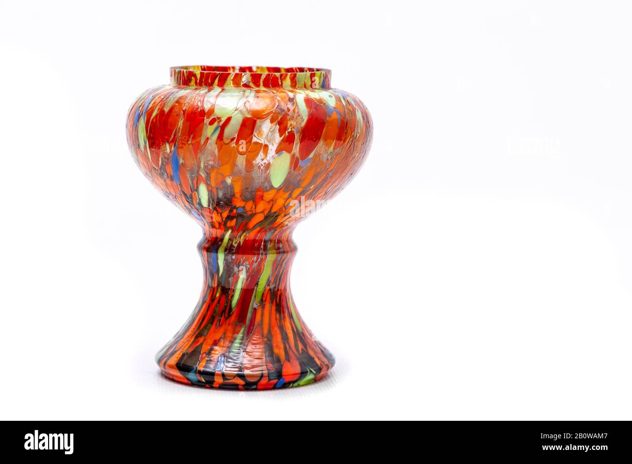 Eine bunte handbemalte Vase (mit vielen Orange- und anderen Farben) auf einem einfarbigen weißen Hintergrund mit Kopierraum. Stockfoto