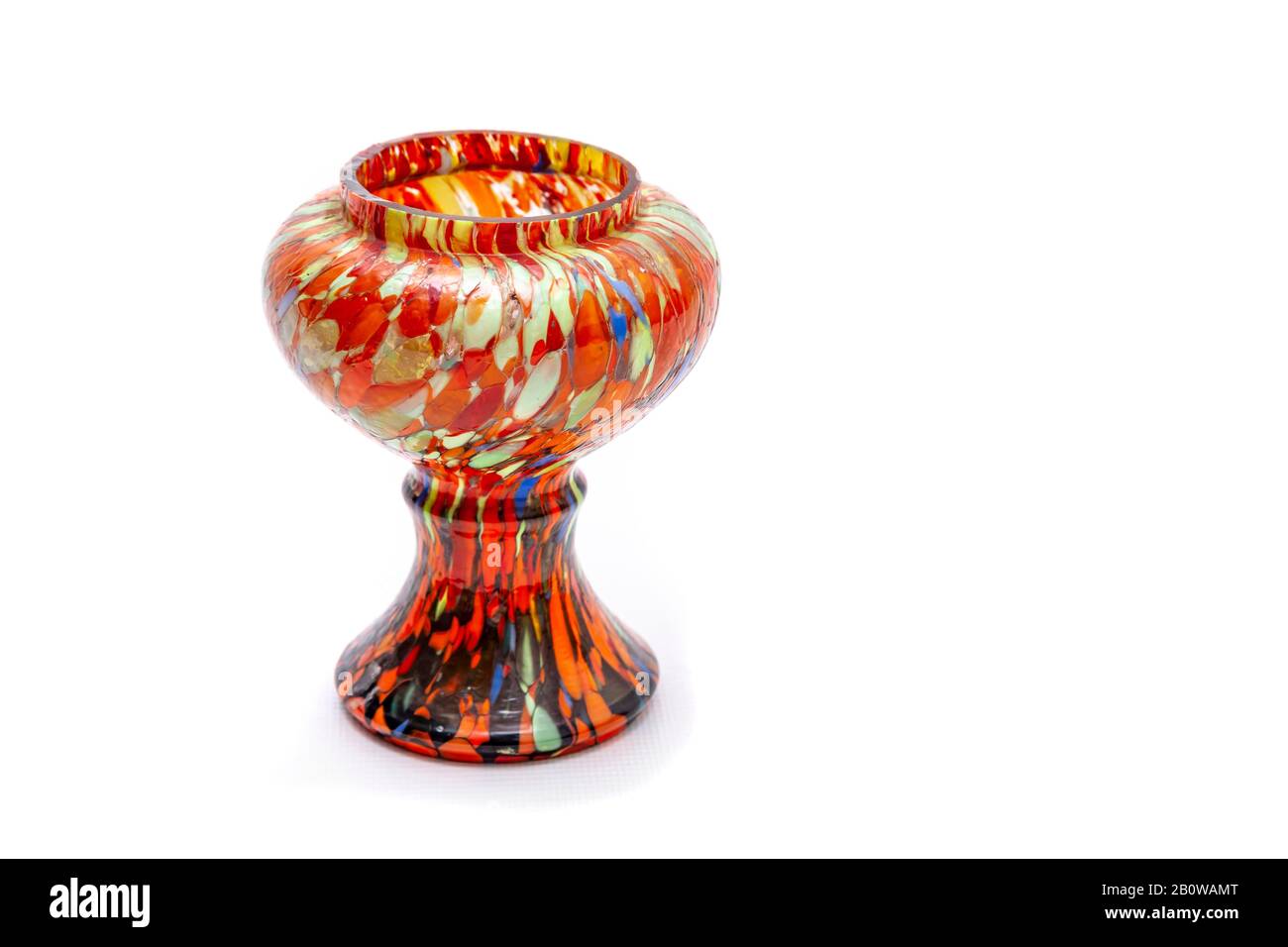 Eine bunte handbemalte Vase (mit vielen Orange- und anderen Farben) auf einem einfarbigen weißen Hintergrund mit Kopierraum. Stockfoto