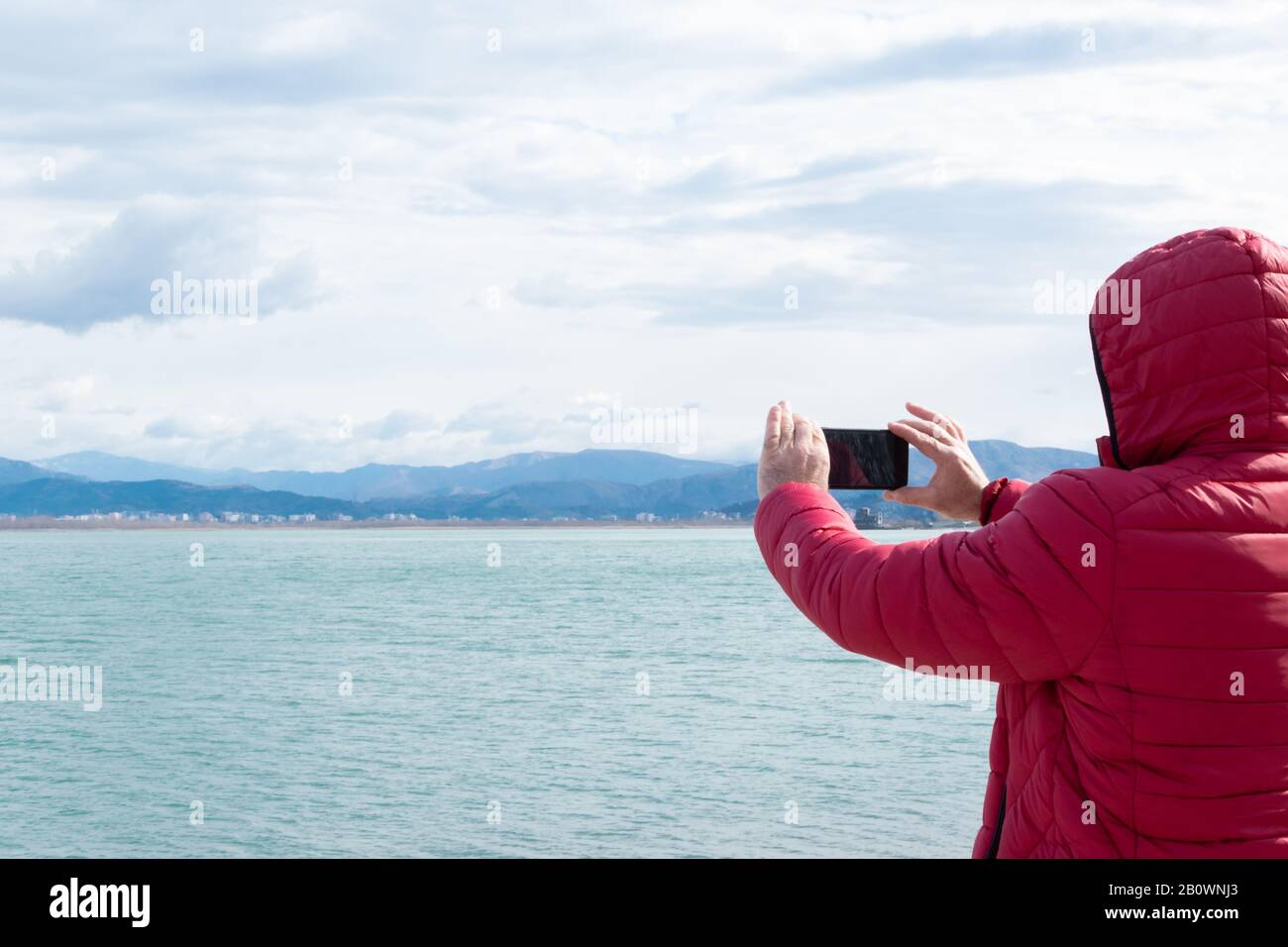 Unerkennbarer Mann, der Fotos mit Smartphone aufgenommen hat. Die Natur bewundern, wanderlust Stockfoto