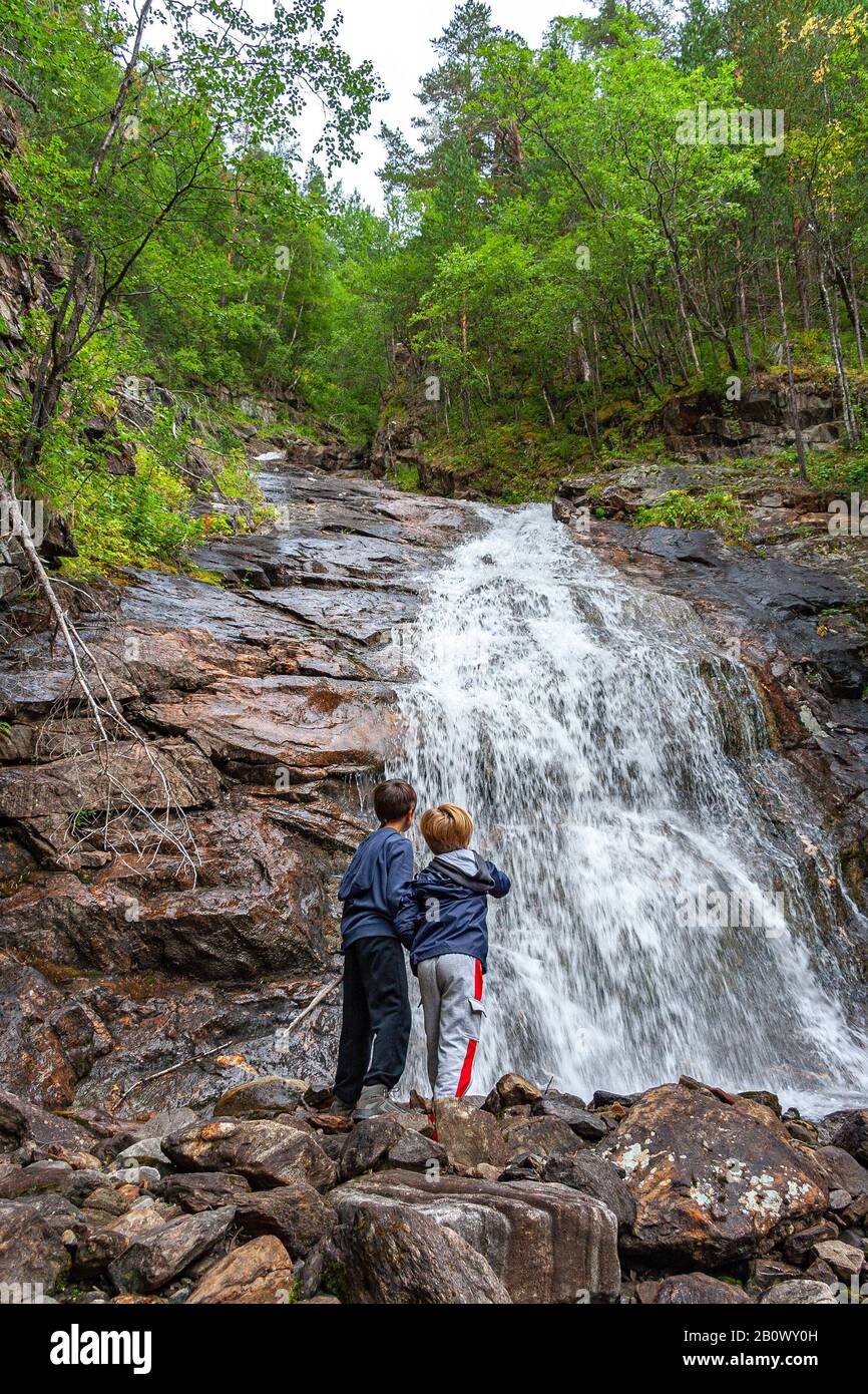 Zwei Kinder am Wasserfall. Nationalpark Junkerdal, Røkland Stockfoto