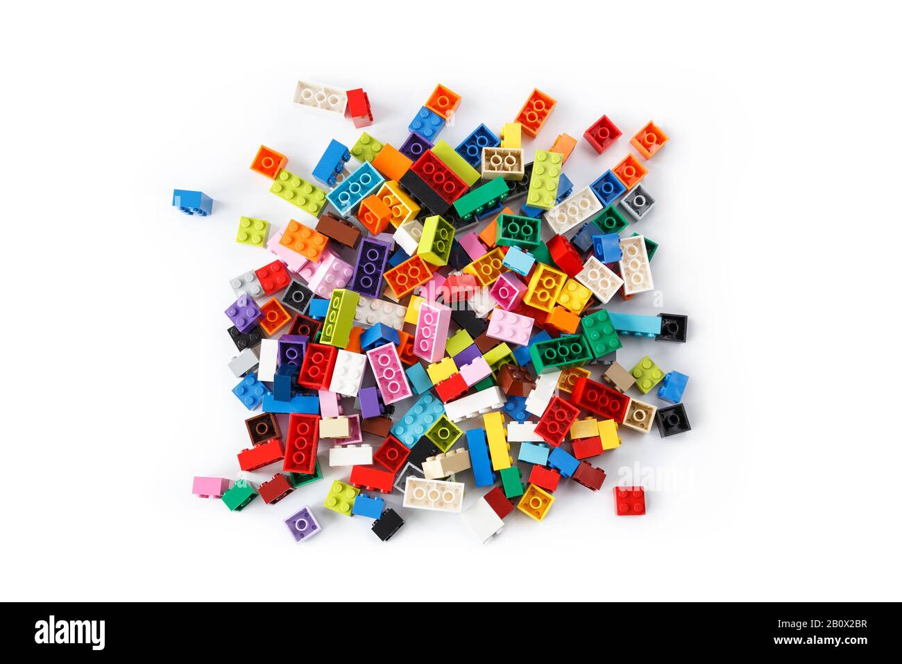 Nahaufnahme eines aufgeräumten Haufens bunter Lego-Steine von oben, isoliert auf weißem Hintergrund. Draufsicht. Stockfoto