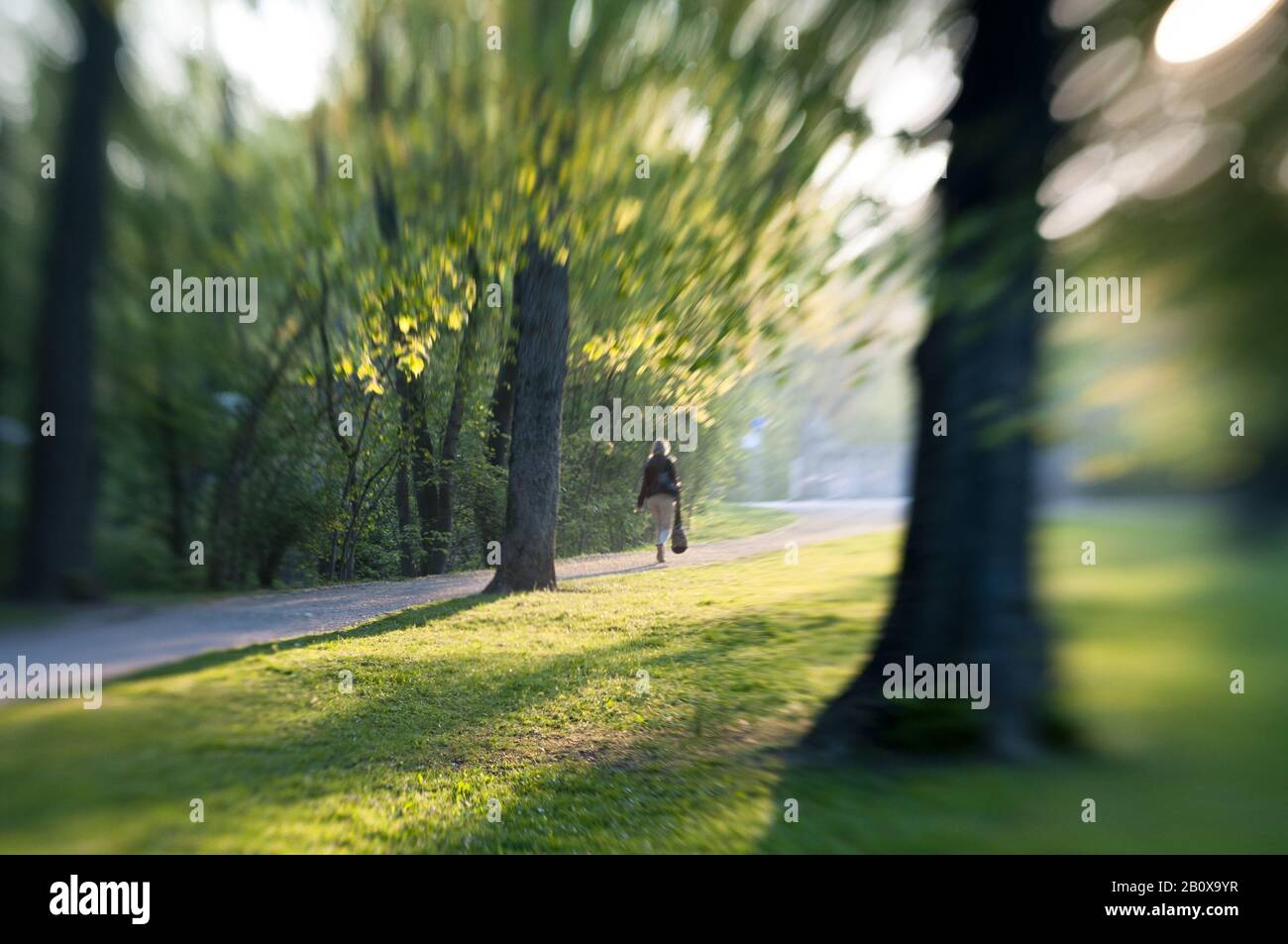 Frau geht durch einen Park, Stockfoto