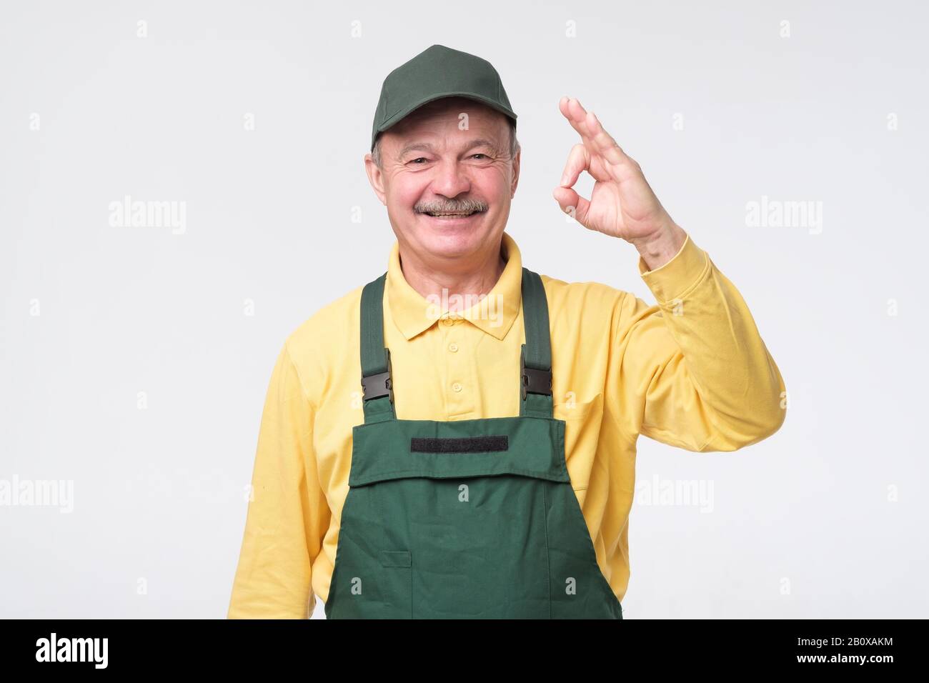 Senior lächelnde Handwerker zeigen eine positive Einstellung ok und stimmen Ihrer Wahl zu. Studio gedreht Stockfoto