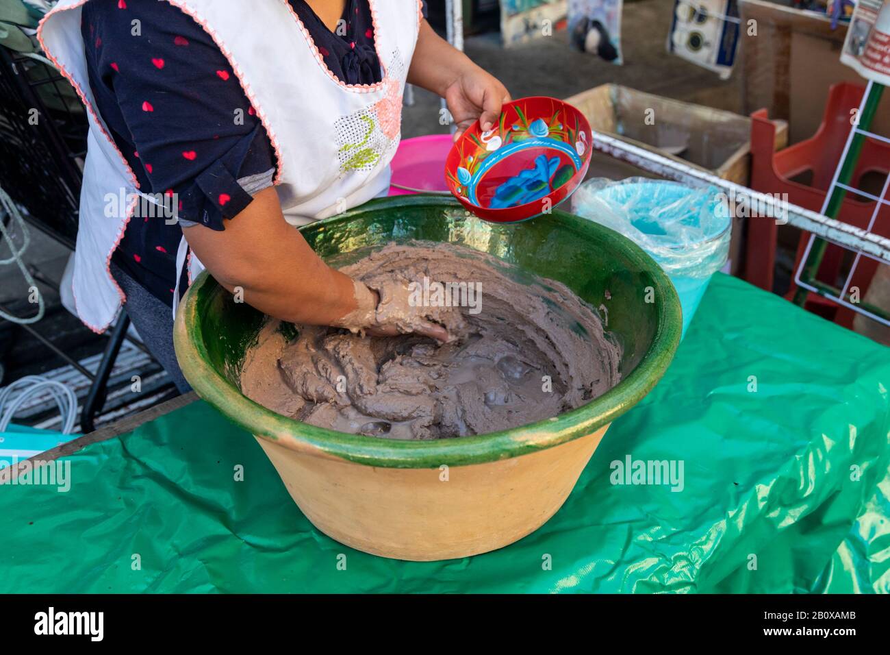Oaxaca, Mexiko - EINE Frau macht ein traditionelles mexikanisches Getränk an einem Lebensmittelstand in einer Straße. Stockfoto