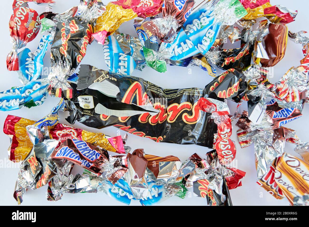 London, Großbritannien - 20. Februar 2020: Zerrissene Umhüllungen einer Mischung beliebter Süßigkeiten-Bars in Miniklassen mit einer großen Mars-Süßwarenbar in der Mitte. Stockfoto