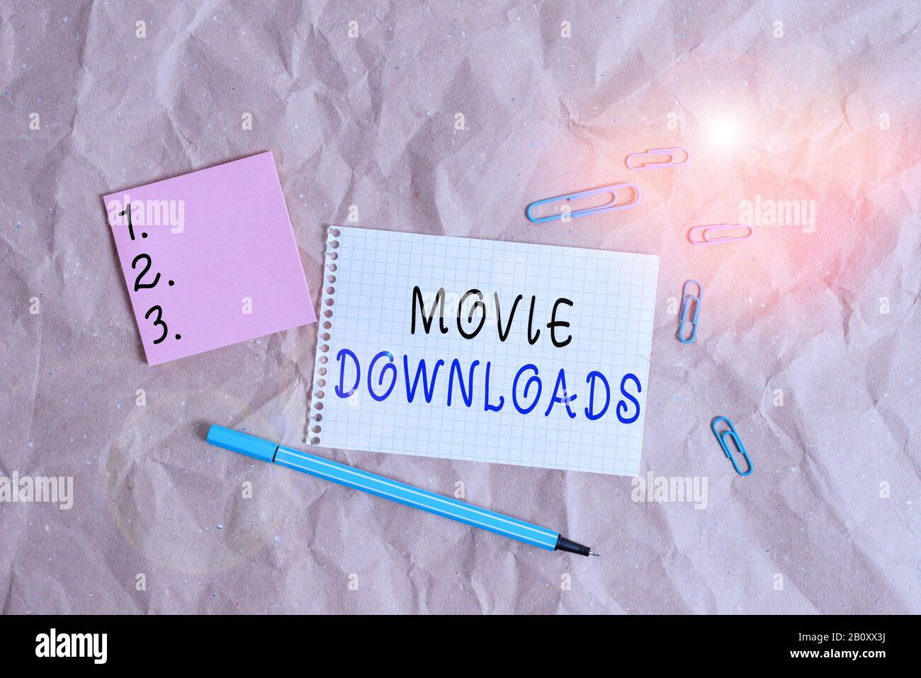 Word Writing Text Movie Downloads. Geschäftsfoto mit Präsentation überträgt den gesamten Film zur lokalen Aufbewahrung und verwendet später den Papierschreibtisch von Papercraft Stockfoto