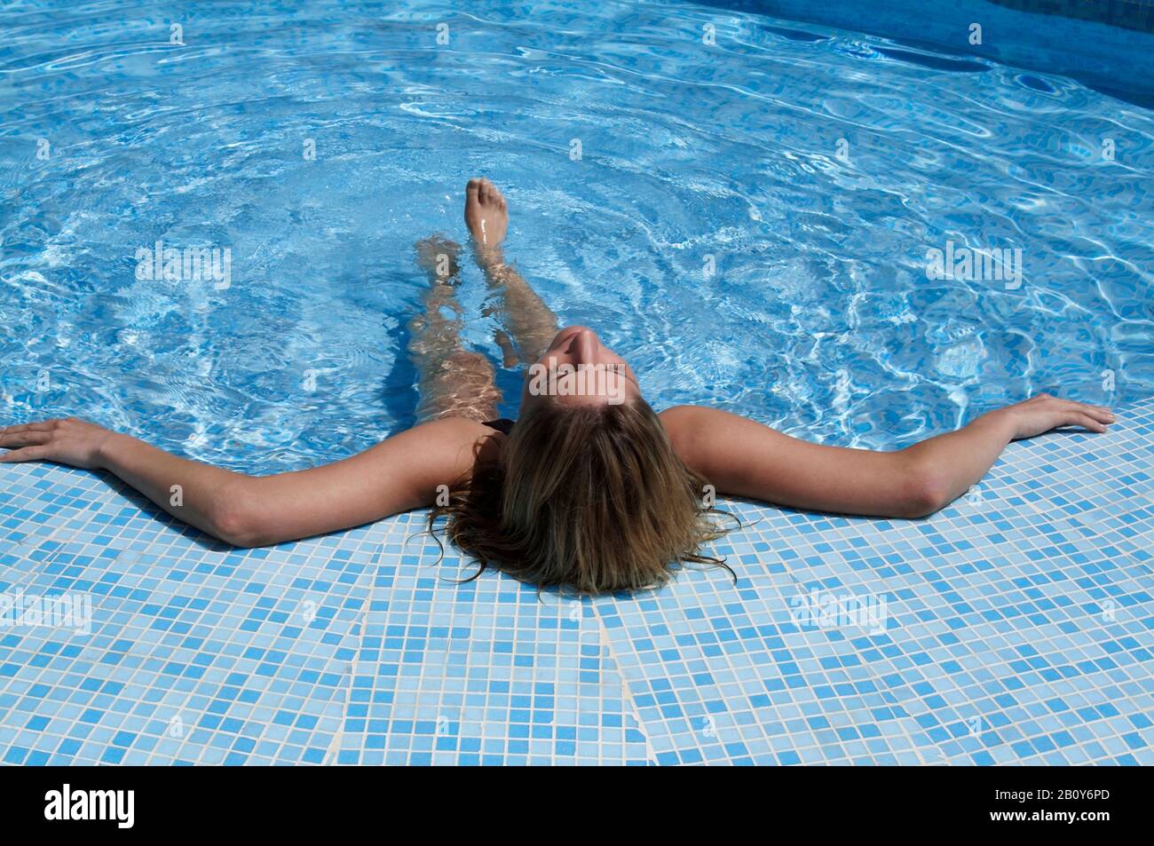 Junge blonde Frau, am Pool liegend, entspannt sich, Cala Ratjada, Mallorca, Spanien Stockfoto