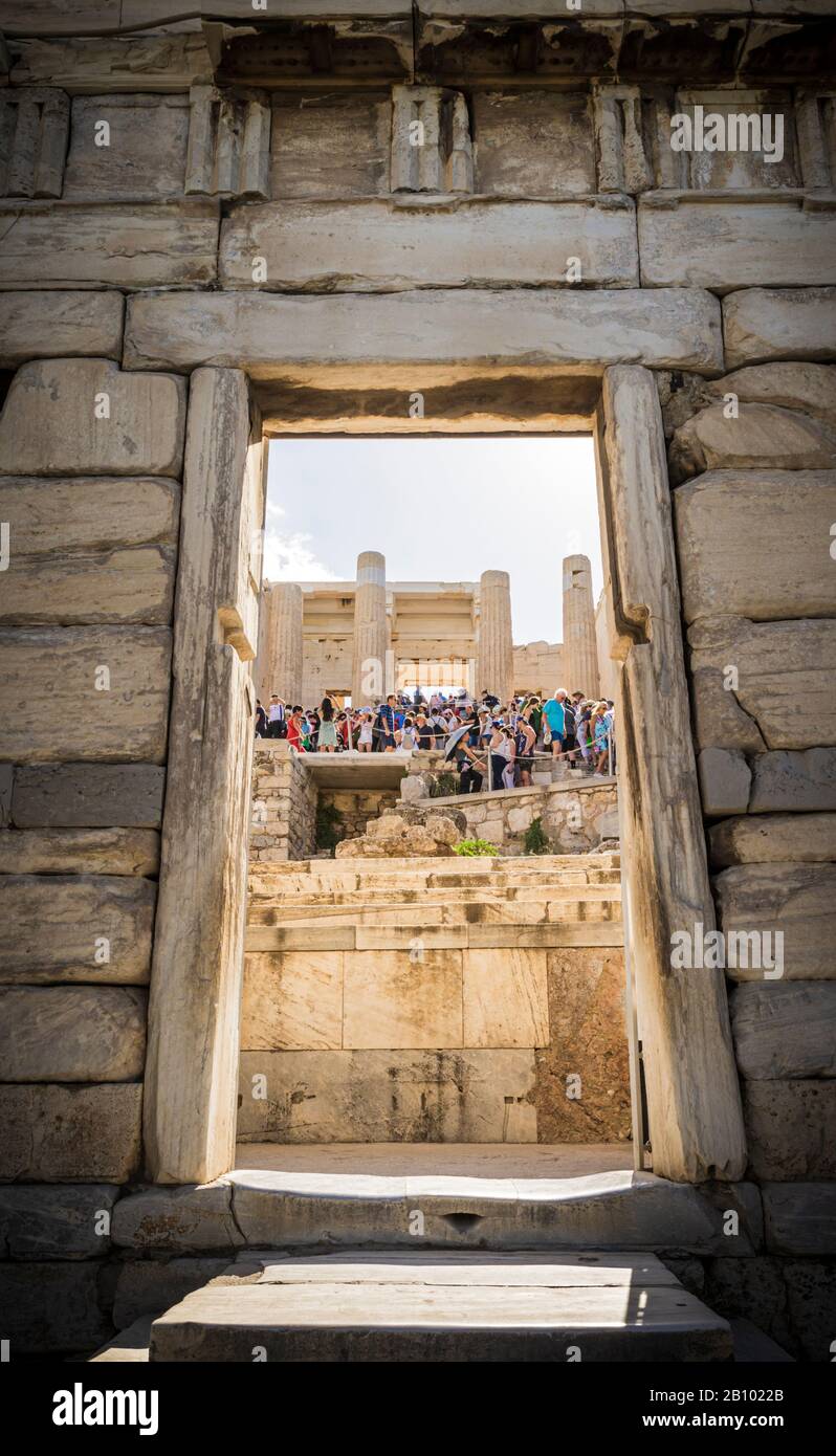 Gerahmter Blick auf Touristen, die die Treppe zur Propyläa, dem großen Eingang zur Akropolis, Athen, Griechenland, hinauf gehen Stockfoto