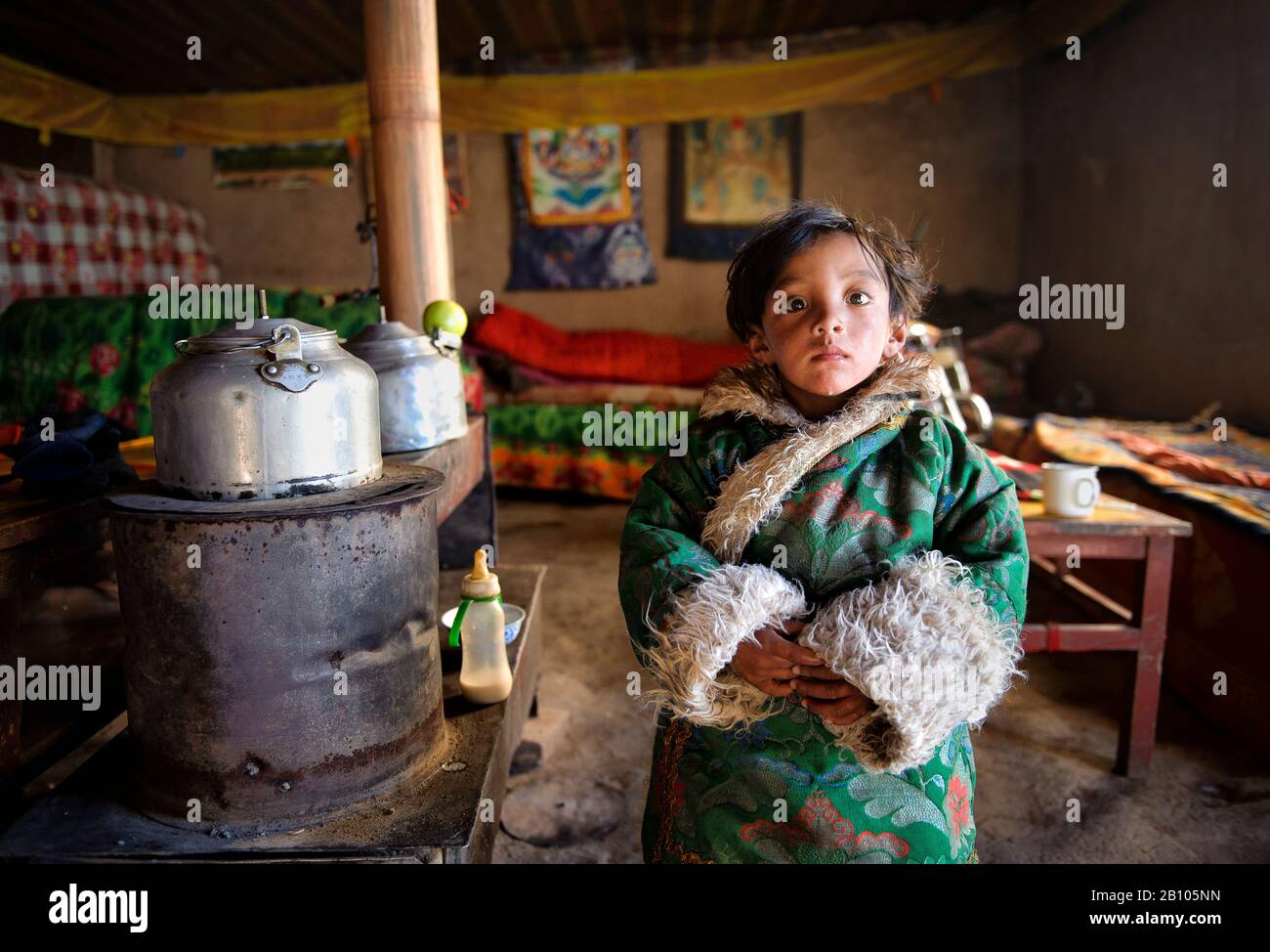 Tibetische Kinder tragen die wunderbar warme Kleidung aus Schaf- und Yakfellen. Eingepackt in sie hält sie warm und hält gleichzeitig das Outfit ihrer Traditionen. Abgelegenes tibetisches Plateau Stockfoto