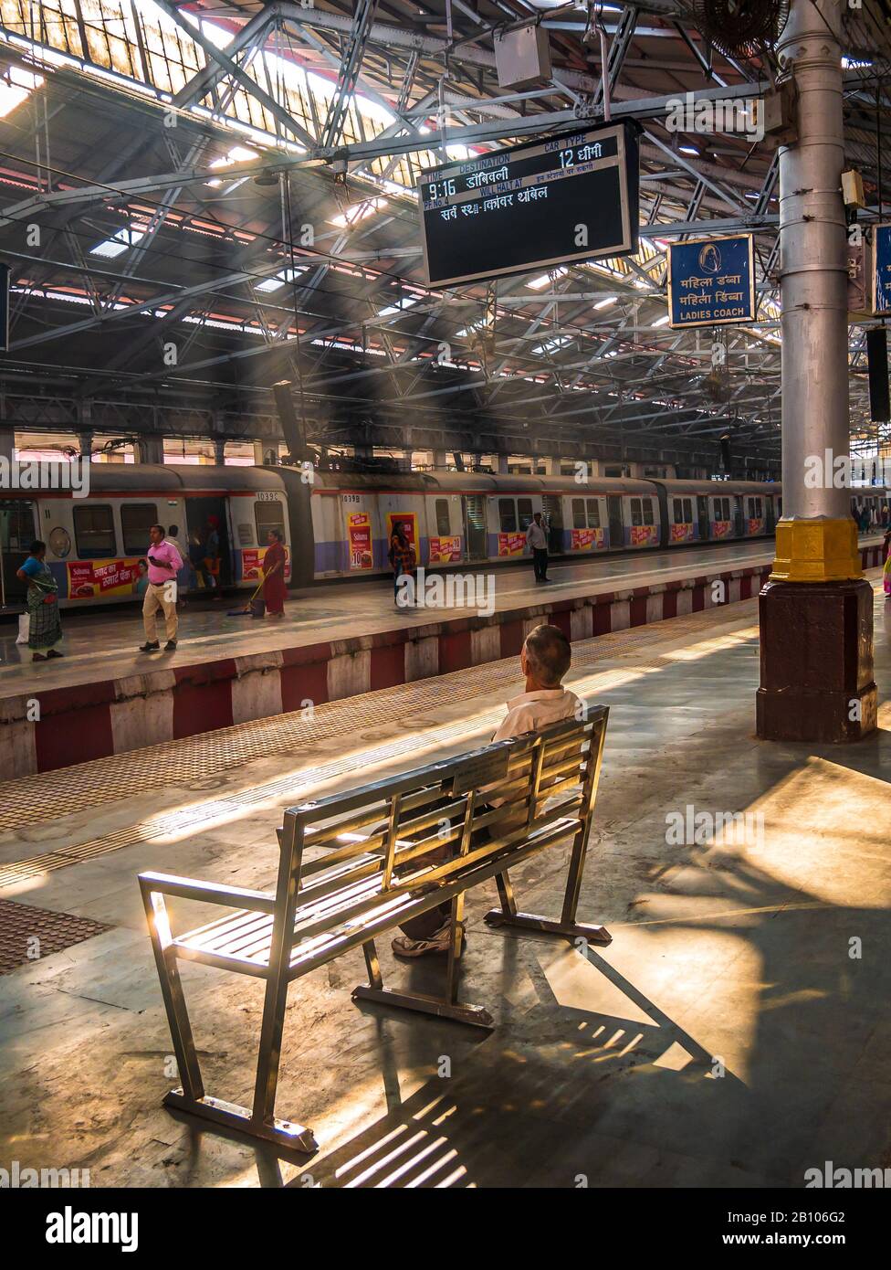 Mumbai, Indien - 18. Dezember 2019: Unidentifizierter Passagier, der auf einer Bank mit Sonnenstrahlen am frühen Morgen im CST-Bahnhof sitzt, einer der busigsten Züge der ST Stockfoto