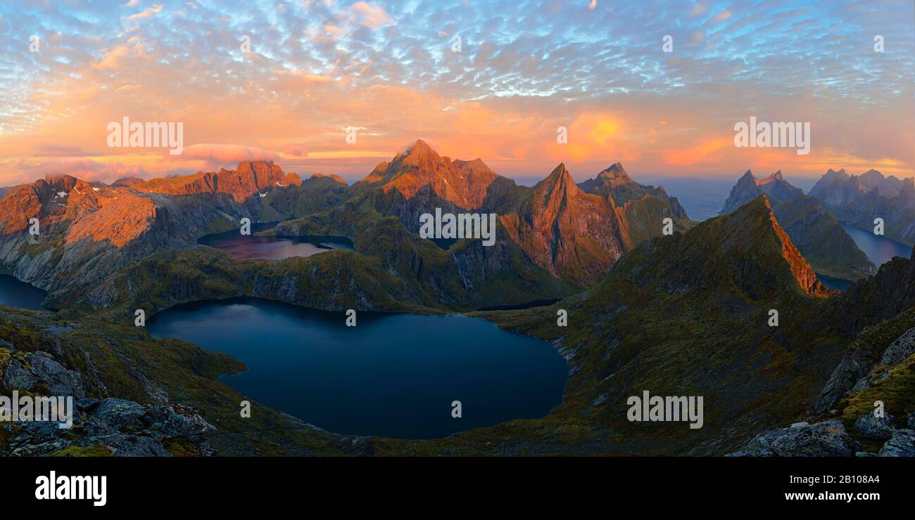 Bergpanorama mit Alpenglow und Schafwolken im Morgenlicht, Munken, Moskenesoy, Lofoten, Norwegen Stockfoto