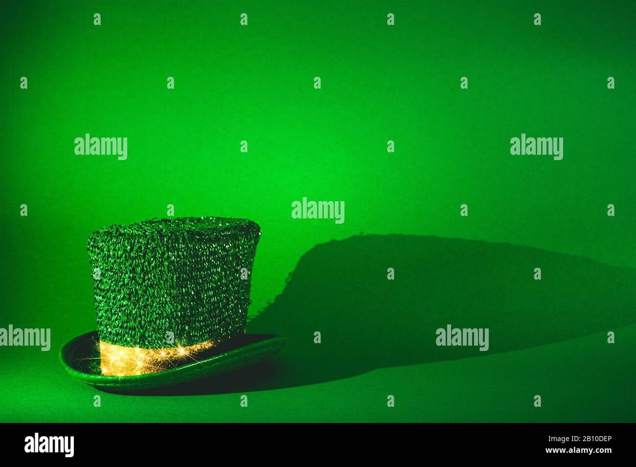 St. Patricks Day, grüner Leprechaun's Hut mit goldenem glänzendem Glitterband auf grünem Hintergrund - Feiern und Feiertage Konzeptbild mit Kopierraum für Stockfoto