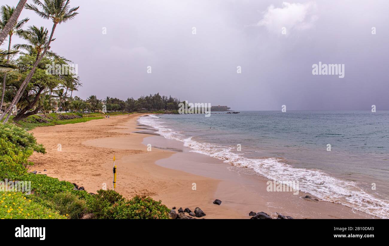 Der leere Strand des Kamaole Beach III Parks. Keine Menschen am Strand wegen eines tropischen Sturms, warnt Erick. Der Himmel ist mit regnerischen Wolken verschlossen. Stockfoto