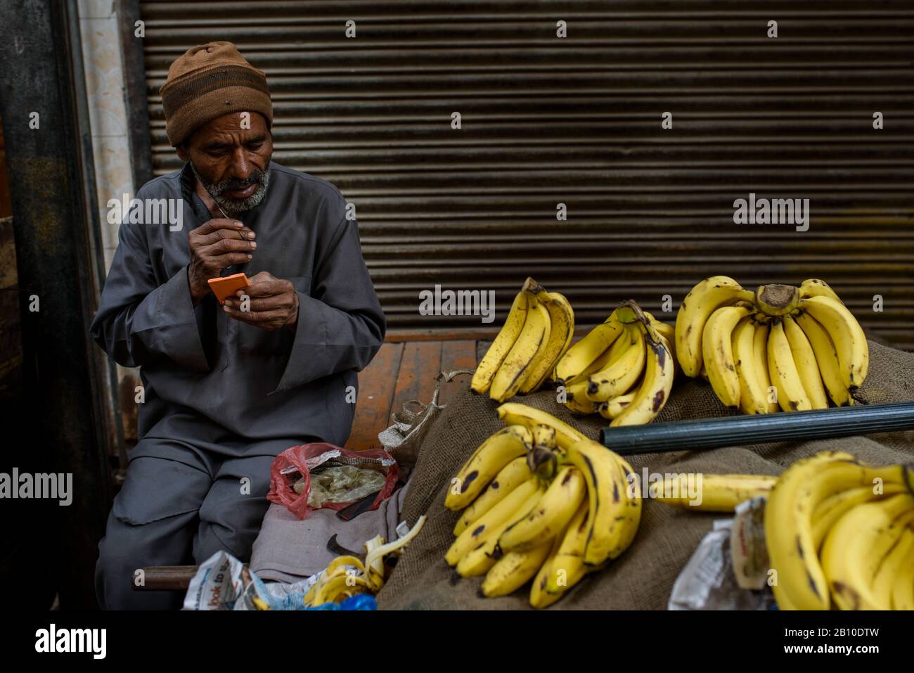 Der Bananenverkäufer schneidet seinen Bart, Old Delhi, Indien Stockfoto