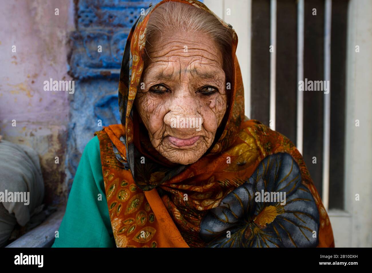Alte Frau, die auf dem Boden vor ihrem Haus sitzt, Jodhpur, Indien Stockfoto