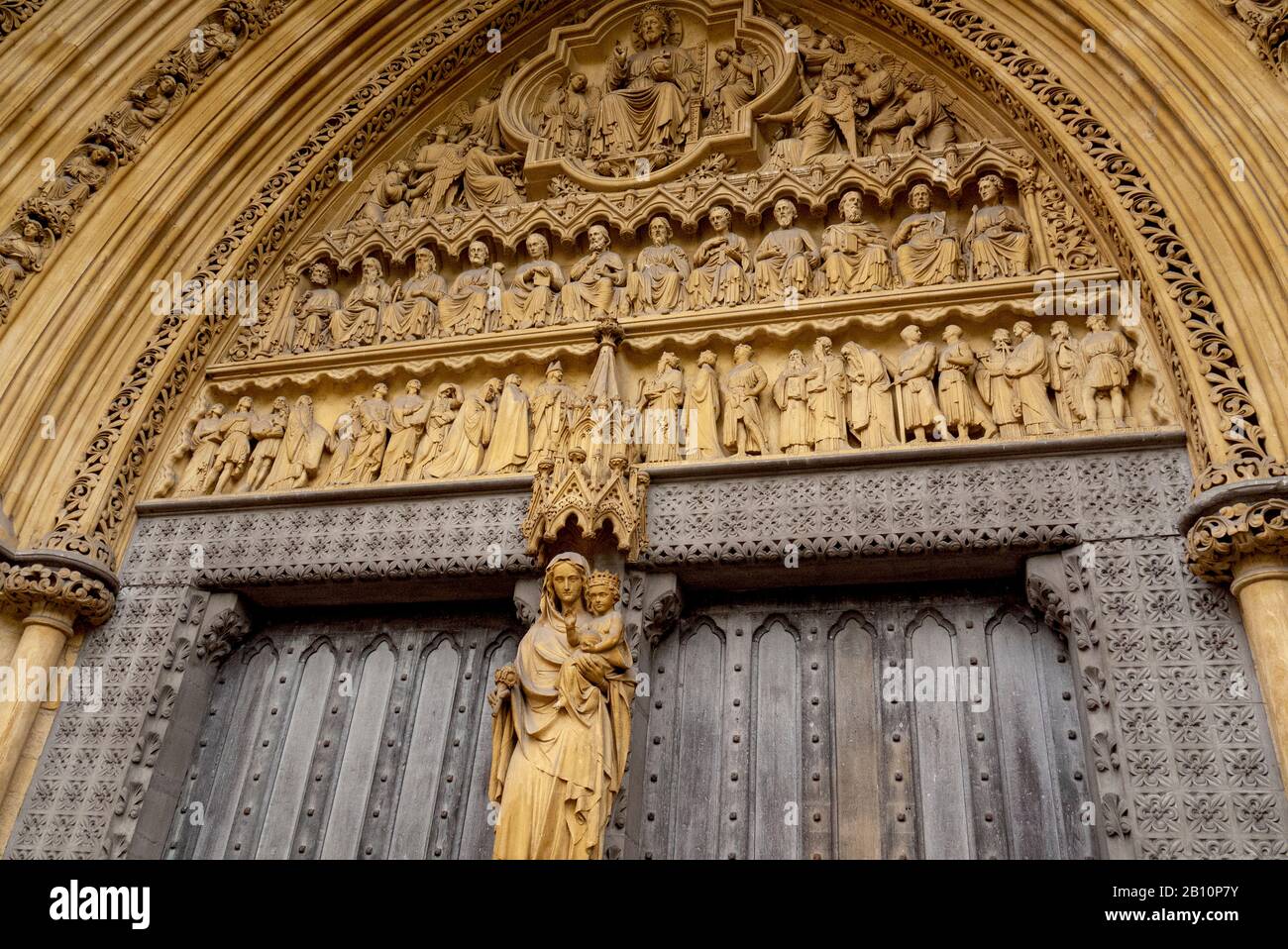 Geschnitzte Steinskulptur Mariens, die das Jesuskind hält. Die Nordtür in der Westminster Abbey. Westminster, London, Großbritannien Stockfoto