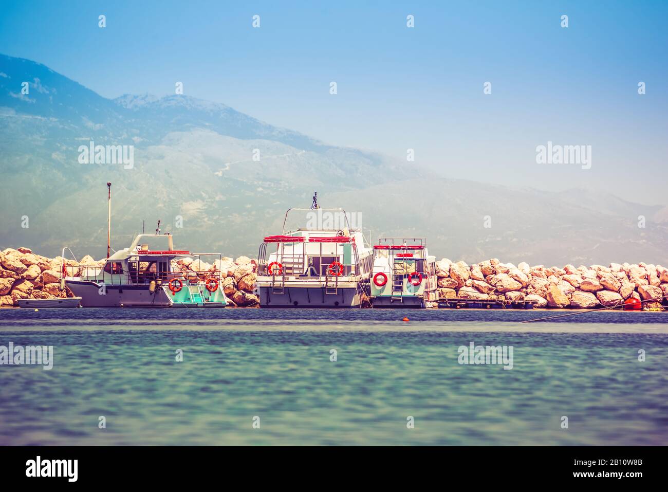 Boote dockten bei Sonnenaufgang am felsigen Pier an Stockfoto