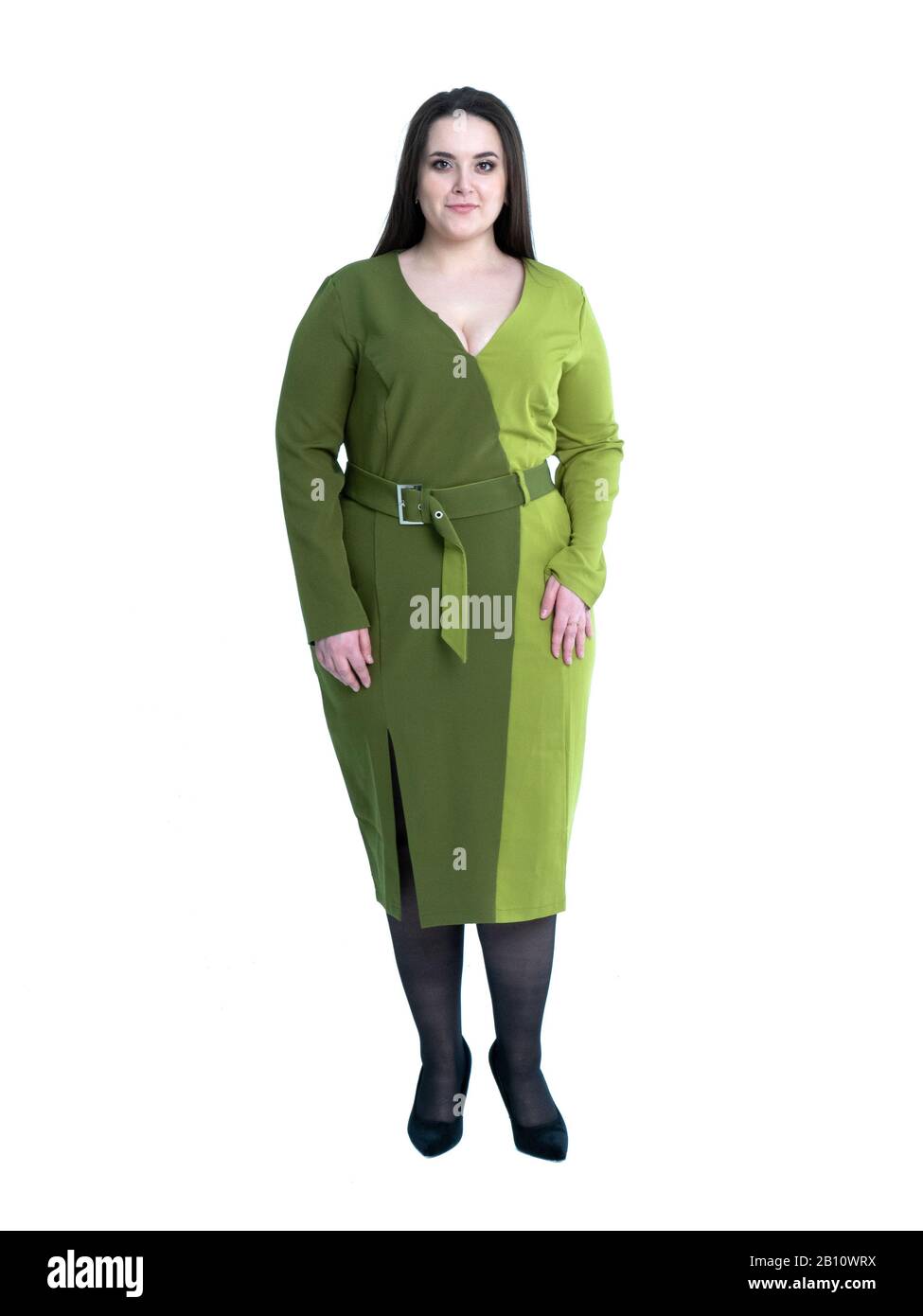 Plus Größe Frau in grünem Kleid posin wie Modell im Studio. Modelltests, Vorderansicht. Stockfoto