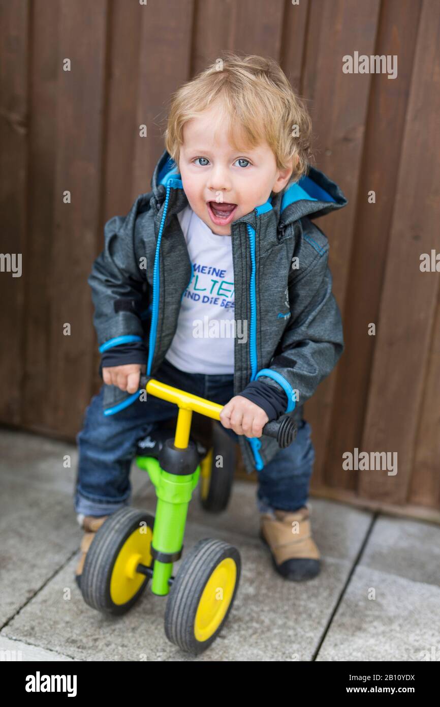 Kleiner Junge mit Laufrad Stockfoto