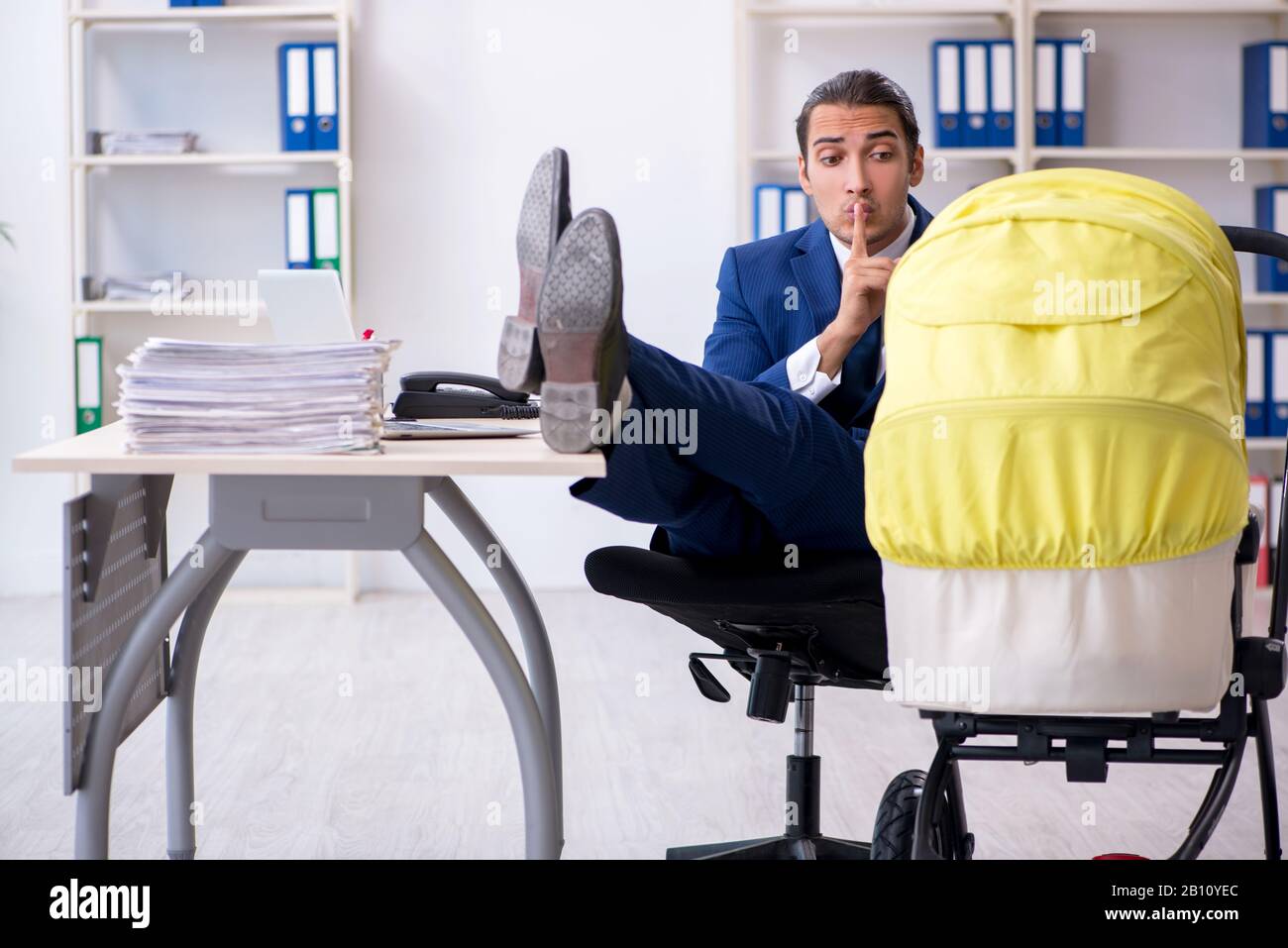 Der junge Vater auf der Suche nach dem Neugeborenen im Büro Stockfoto